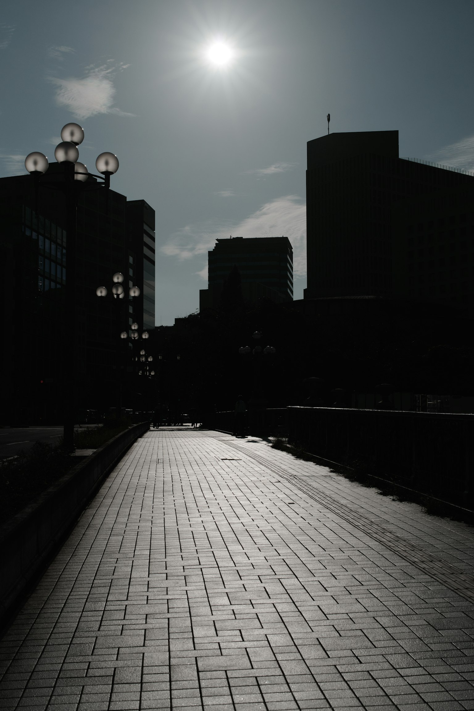 Silhouette di edifici con un marciapiede illuminato dal sole