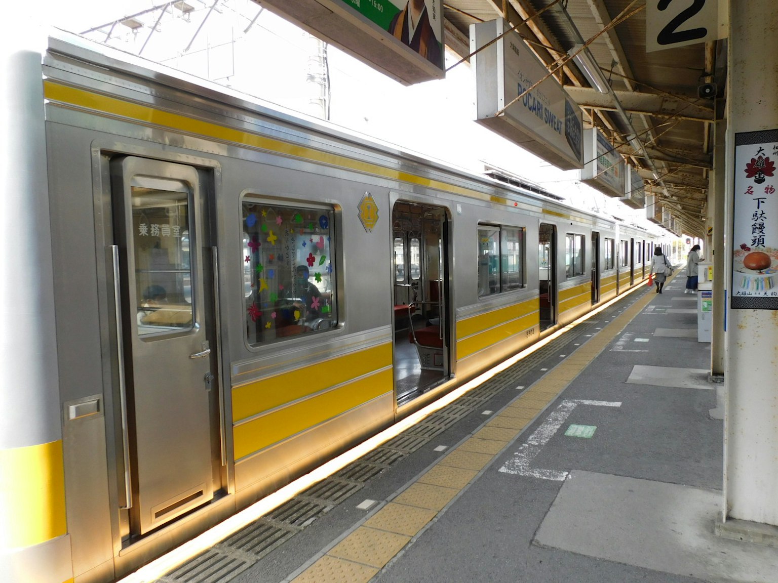 รถไฟสีเงินและสีเหลืองจอดอยู่ที่ชานชาลาสถานี