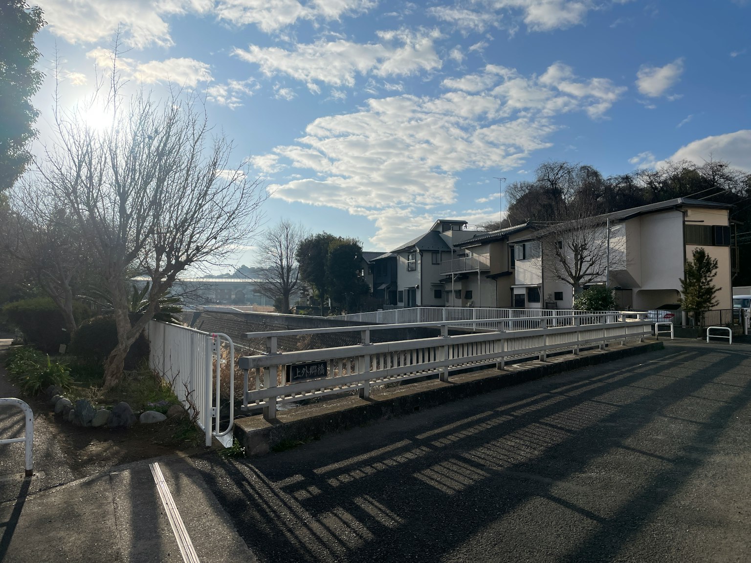 Eine malerische Aussicht auf ein Wohngebiet mit einer Brücke unter einem blauen Himmel und weißen Wolken