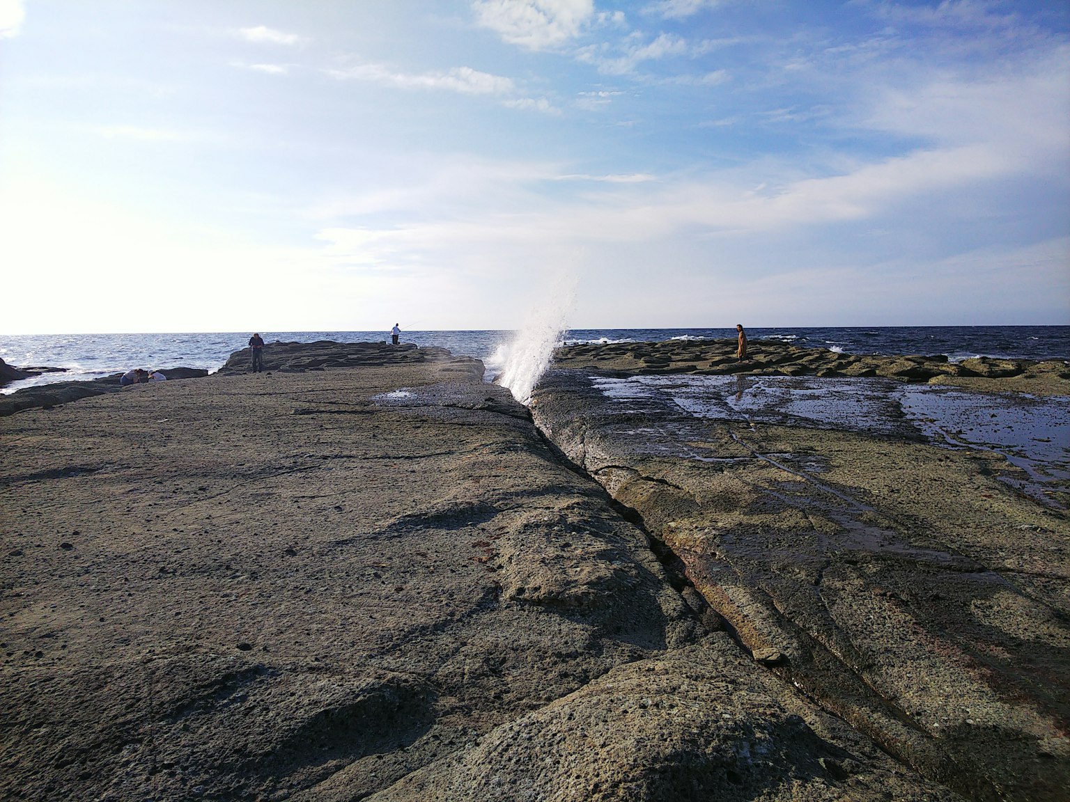 Coastal rock formation with water spouting from the ocean