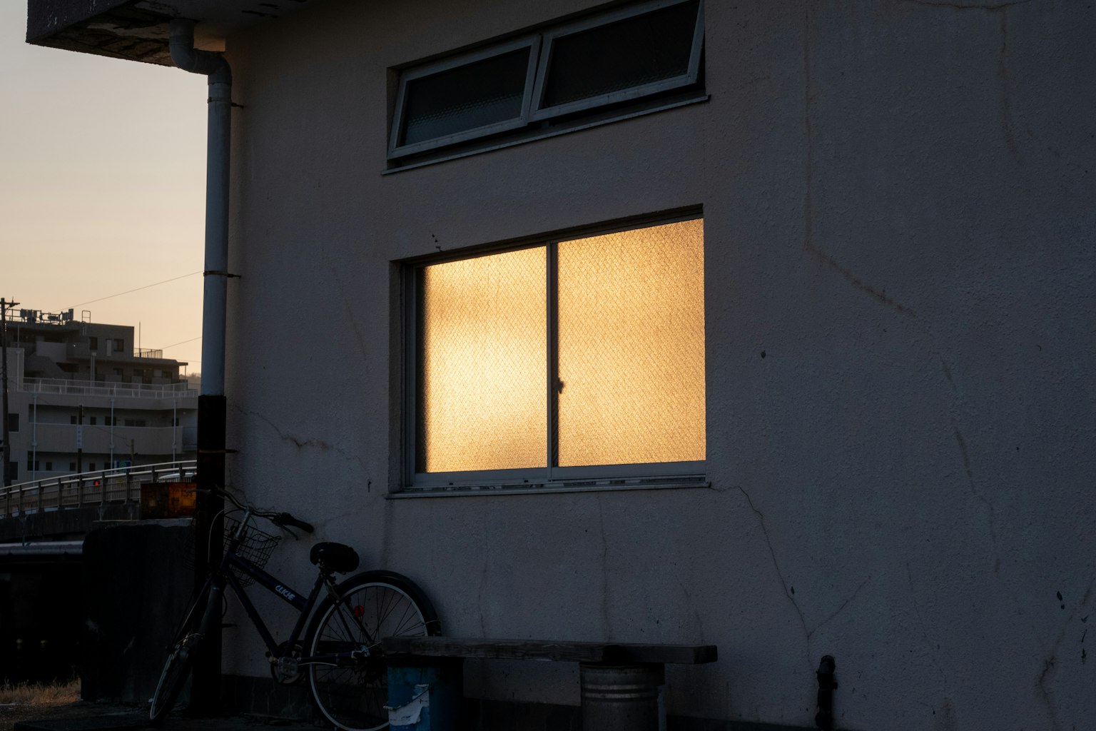 黃昏時窗戶反射的溫暖光線在白色牆壁的房子上