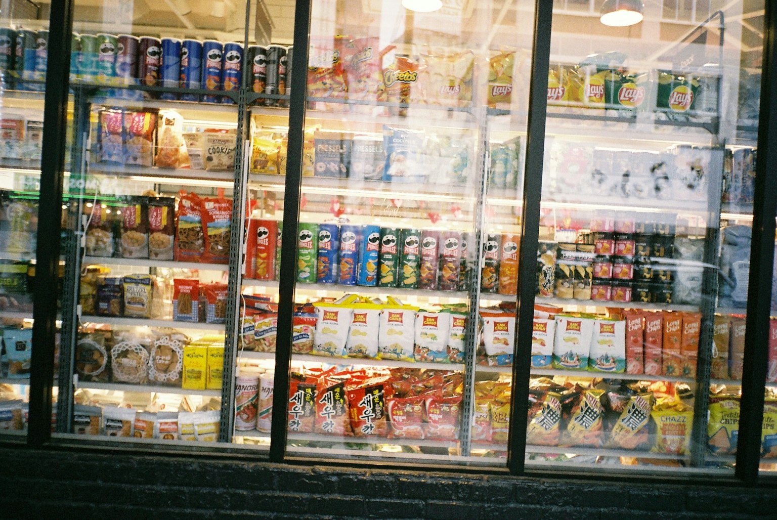 A display of various drinks and snacks in a refrigerator