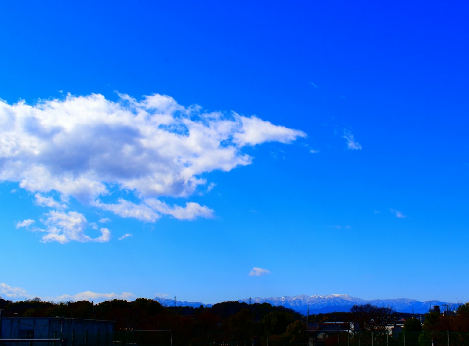 ทิวทัศน์ที่สวยงามพร้อมท้องฟ้าสีฟ้าและเมฆสีขาวภูเขาอยู่เบื้องหลัง
