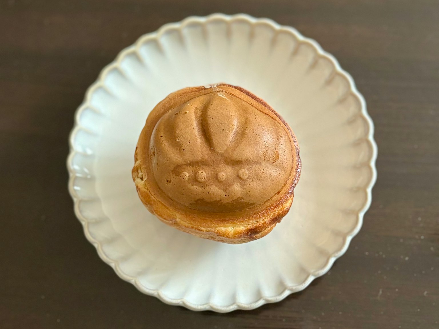 一個放在白色盤子上的帶有花紋頂部的烘焙食品