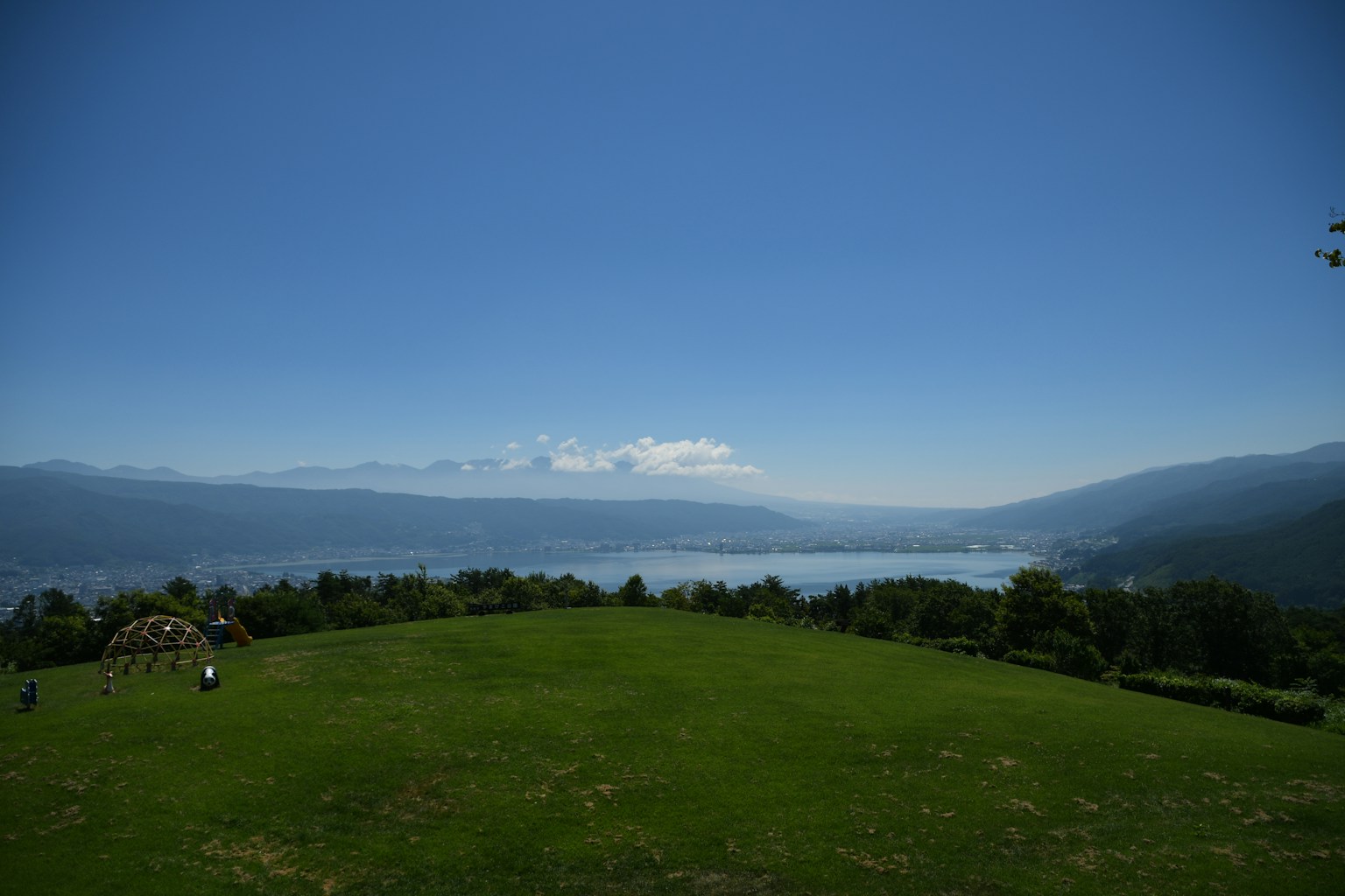 俯瞰湖泊和藍天的綠丘風景