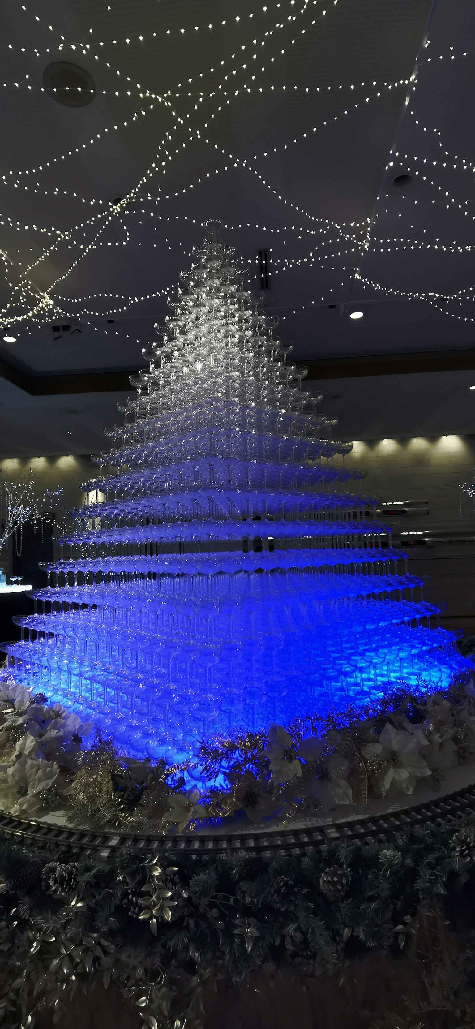 Ein dekorierter Weihnachtsbaum, der blaues Licht in einem Innenraum ausstrahlt