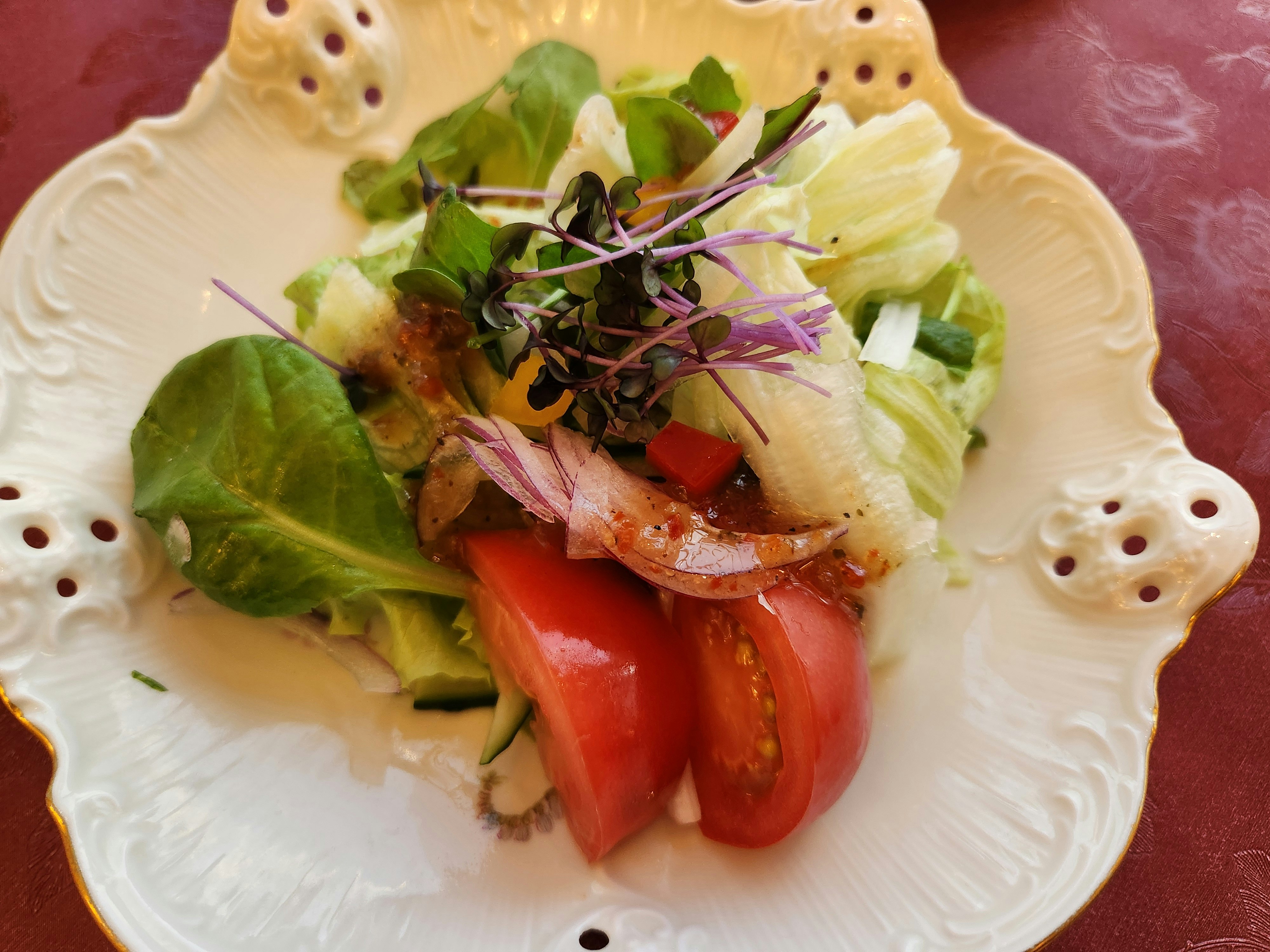白い皿に盛られたサラダとトマトの前菜