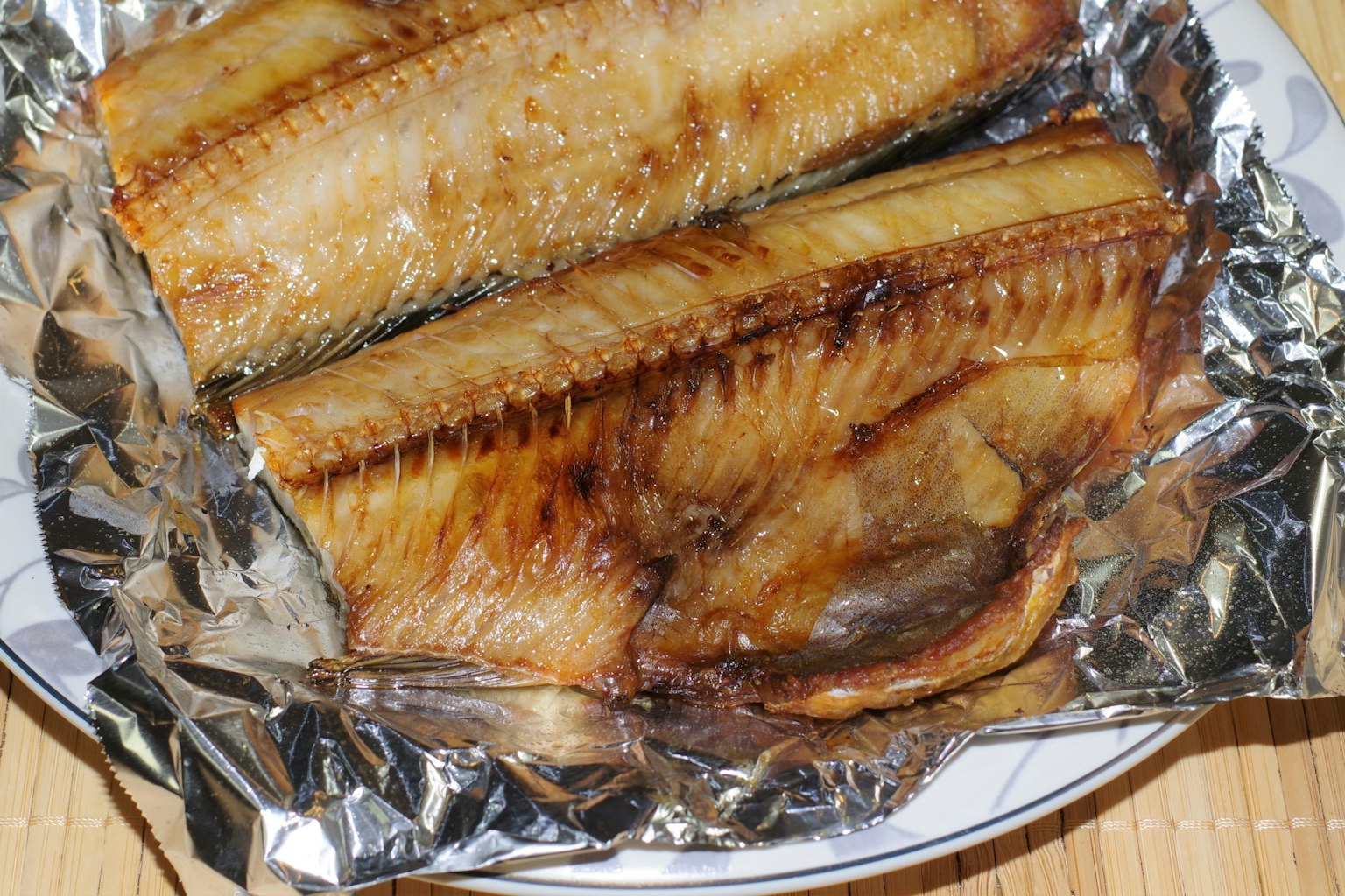 Filets de poisson grillés servis sur une assiette avec du papier d'aluminium