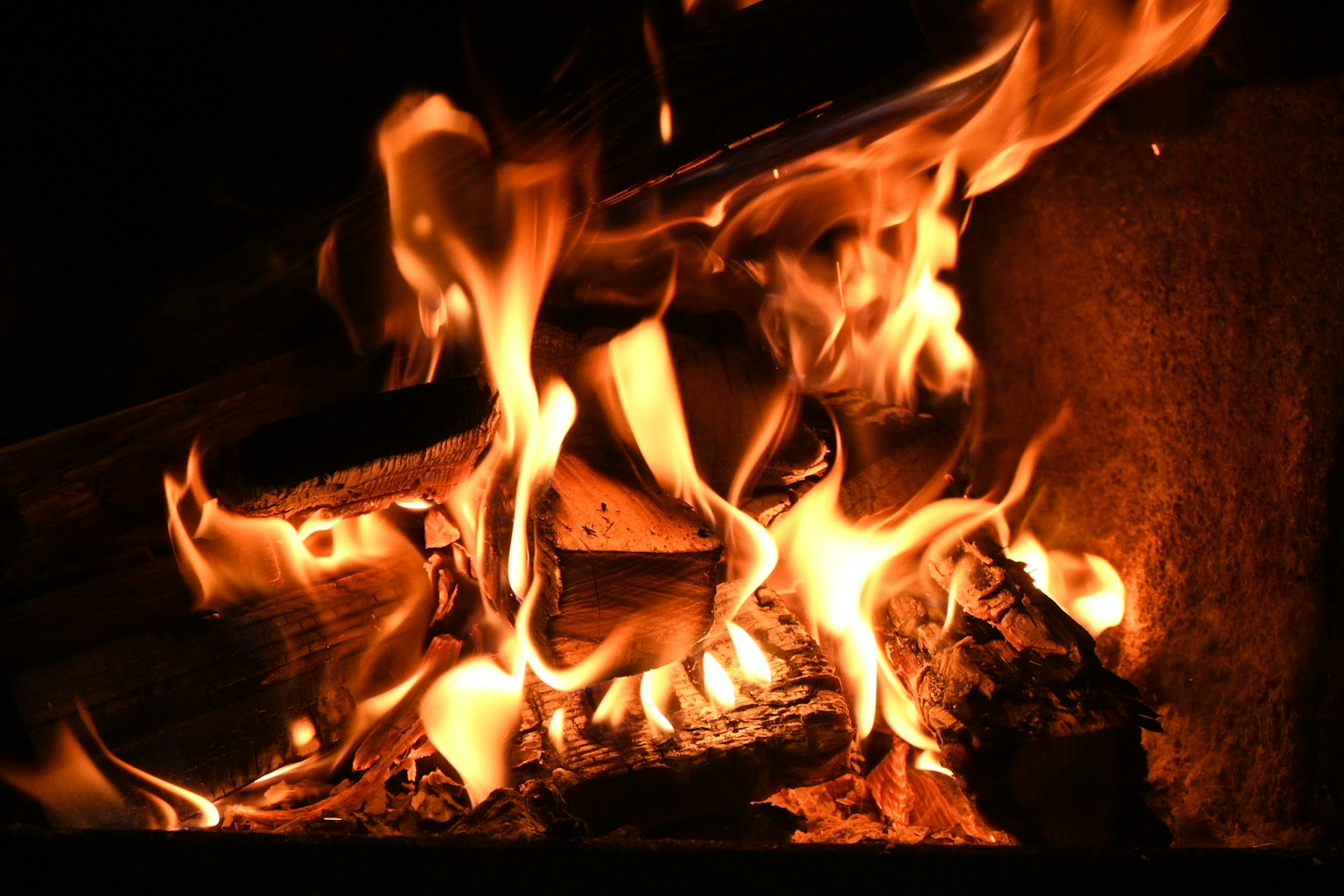 Close-up of a warm fire with flames and glowing embers