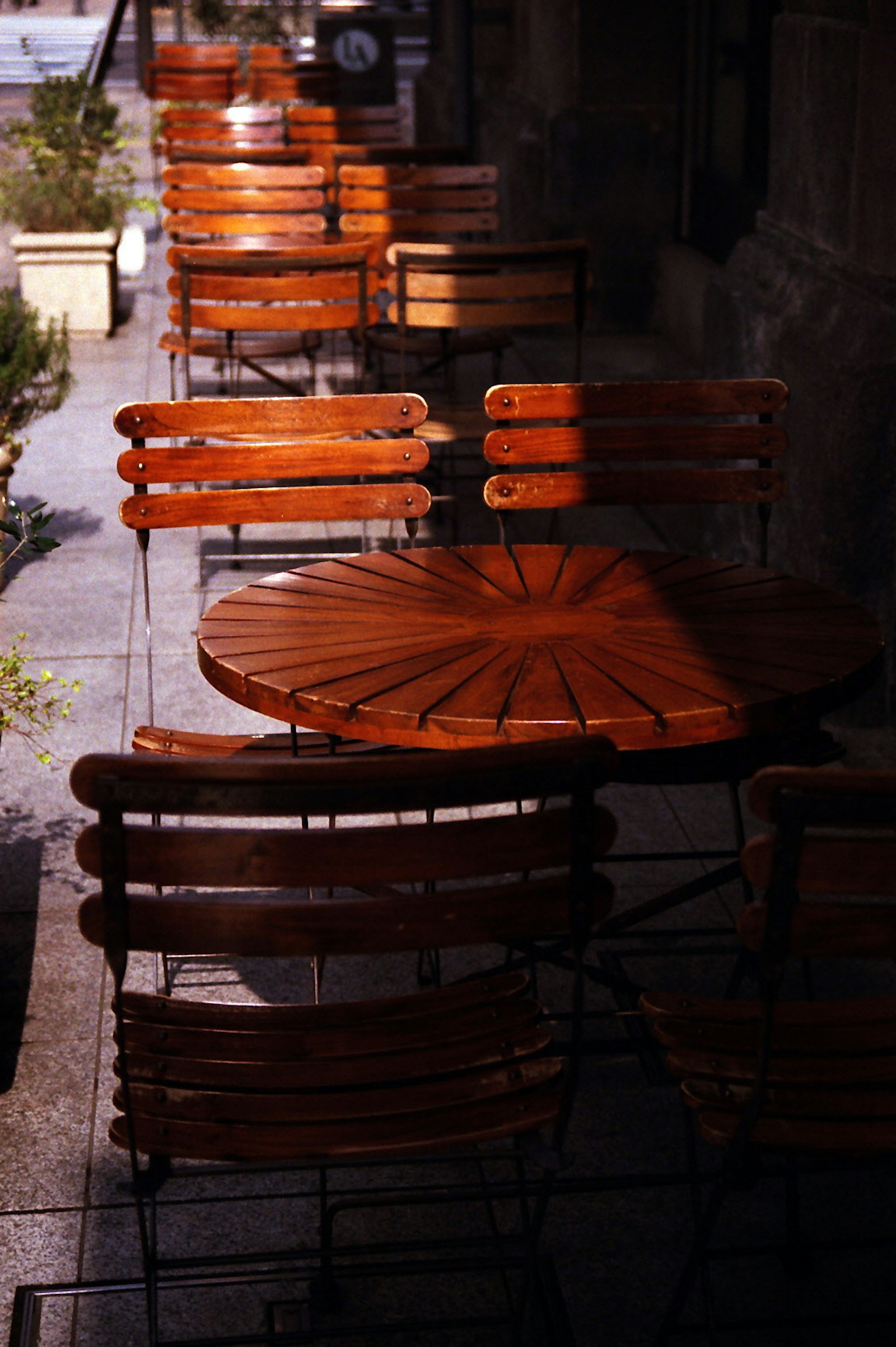 Mesas y sillas de madera dispuestas afuera de un café