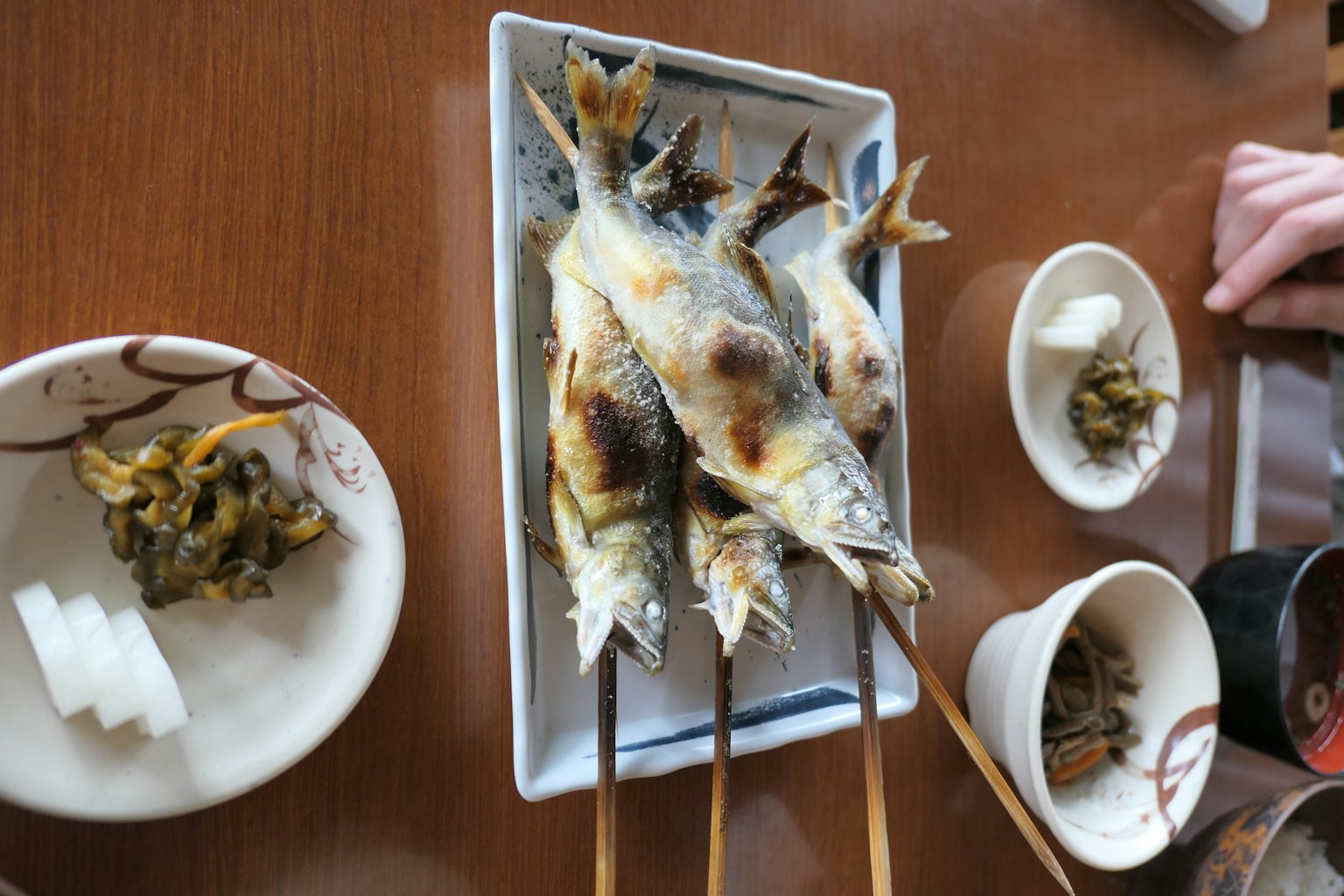Poisson grillé sur brochettes servi dans une assiette avec des plats d'accompagnement