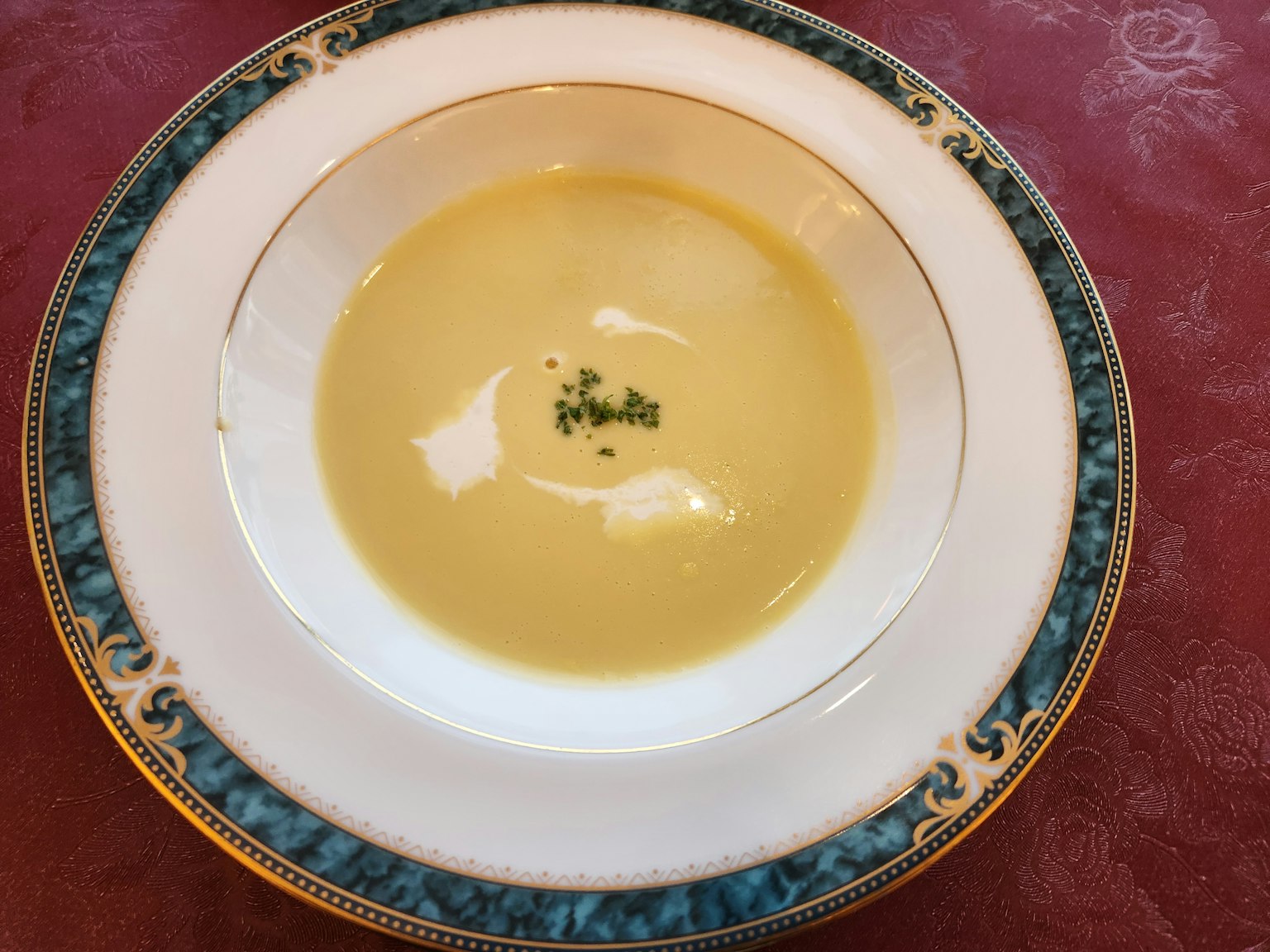 Soupe crémeuse dans un bol blanc garnie d'herbes finement hachées