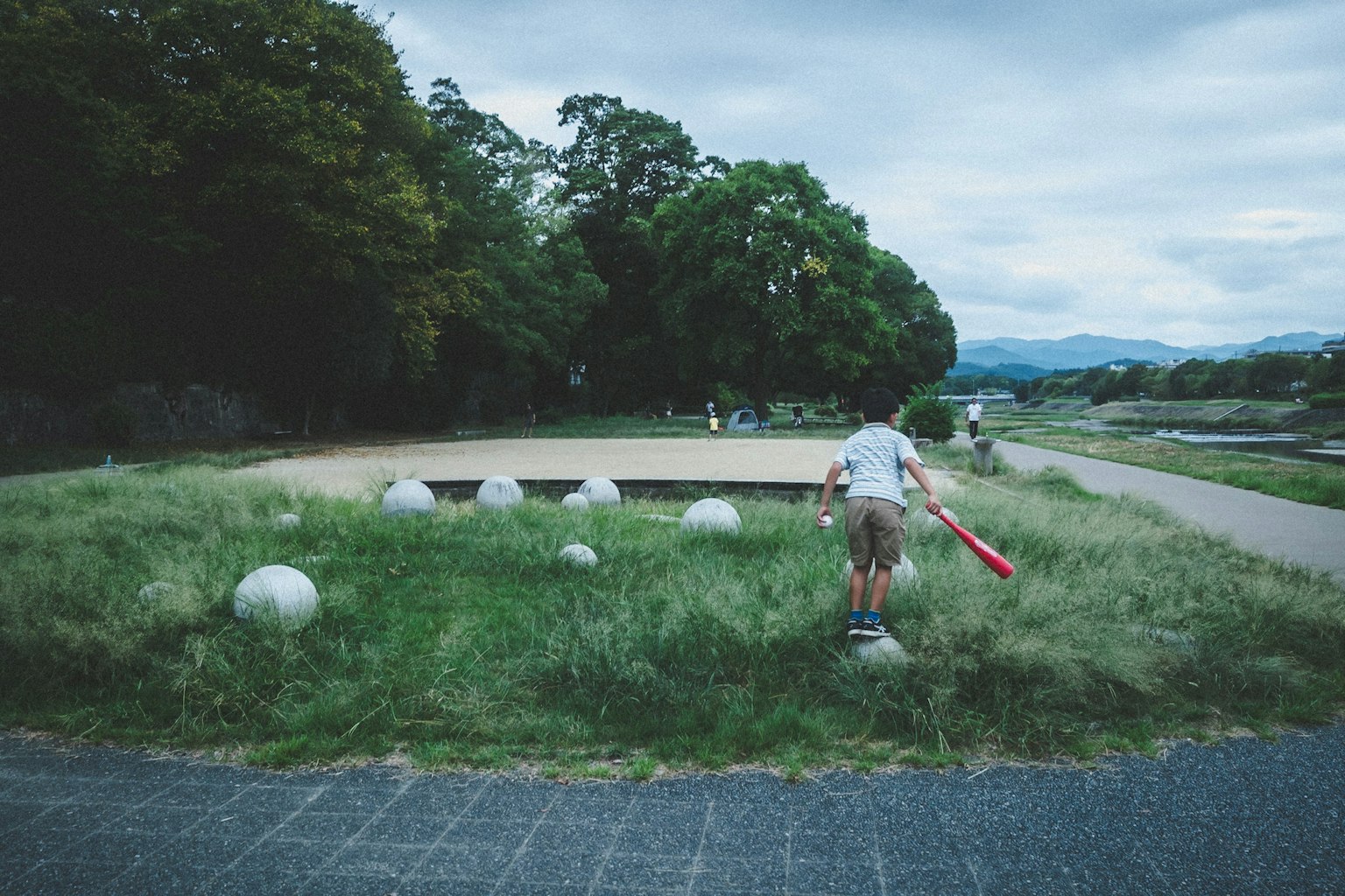 孩子在公園裡玩耍與球形雕塑