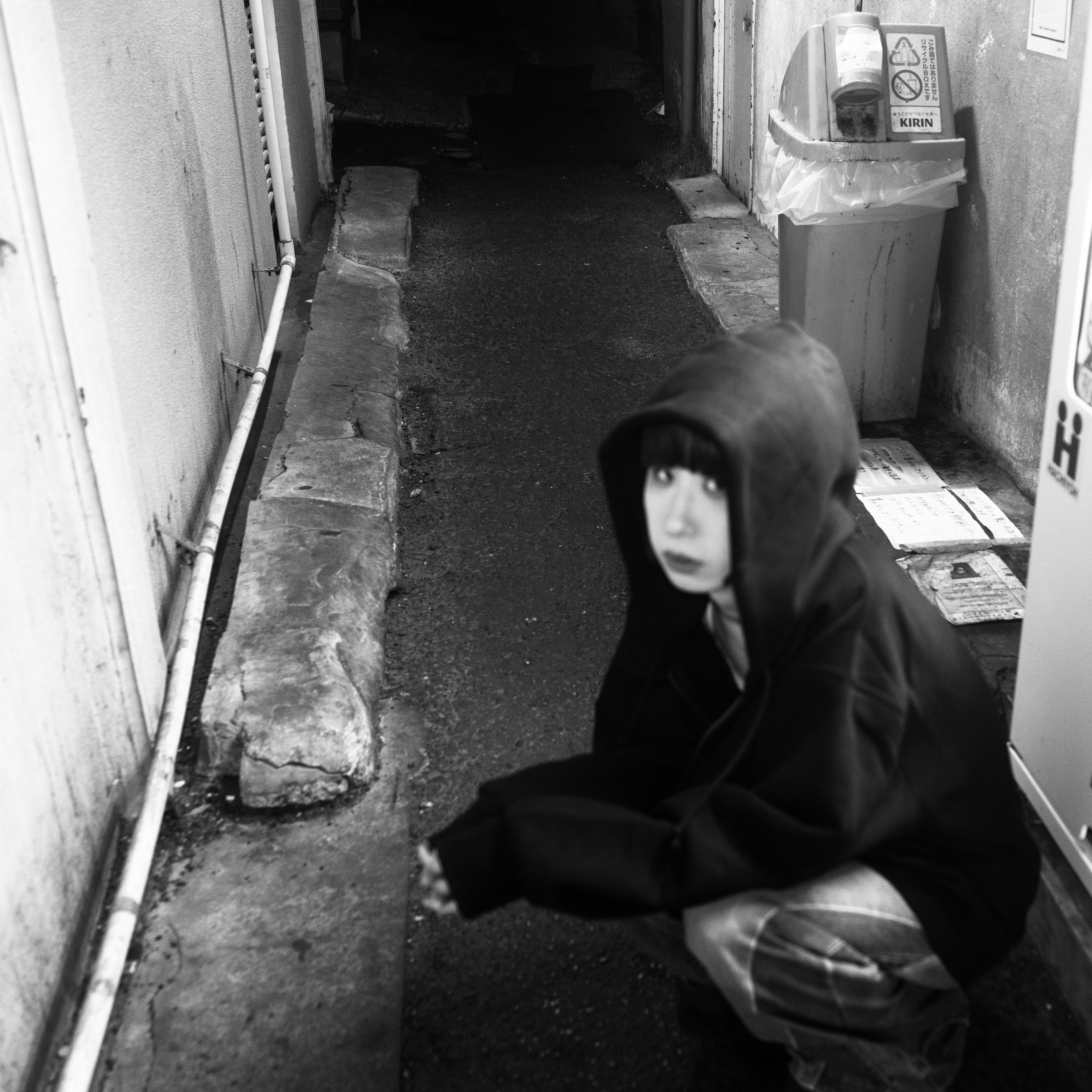 狭窄小巷里戴兜帽的人回头看
