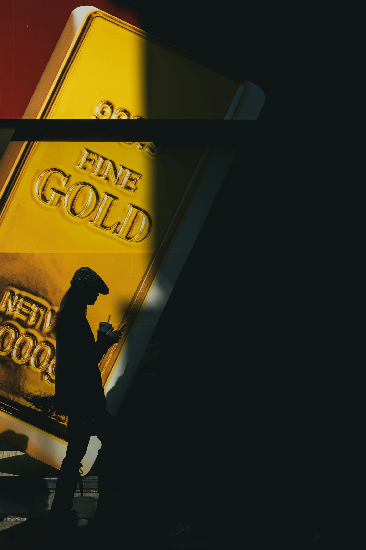 Silhouette of a person standing in front of a gold bar