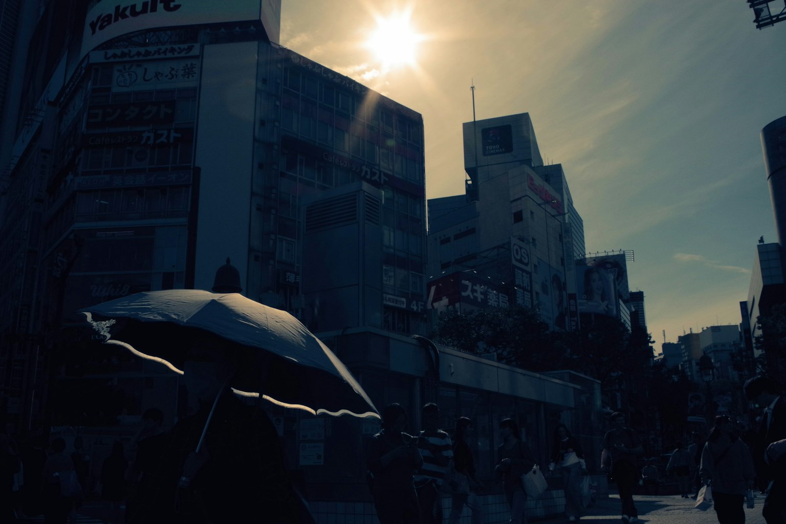 行人在建築物間走動的輪廓 陽光照耀著城市景觀