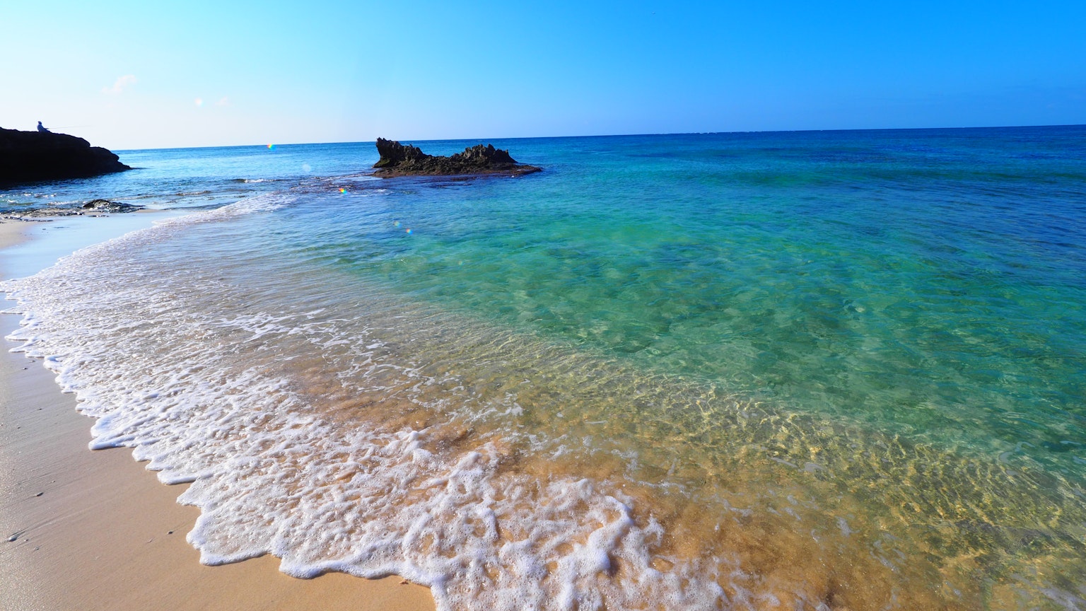 Beautiful beach scene with blue ocean and white sandy shore