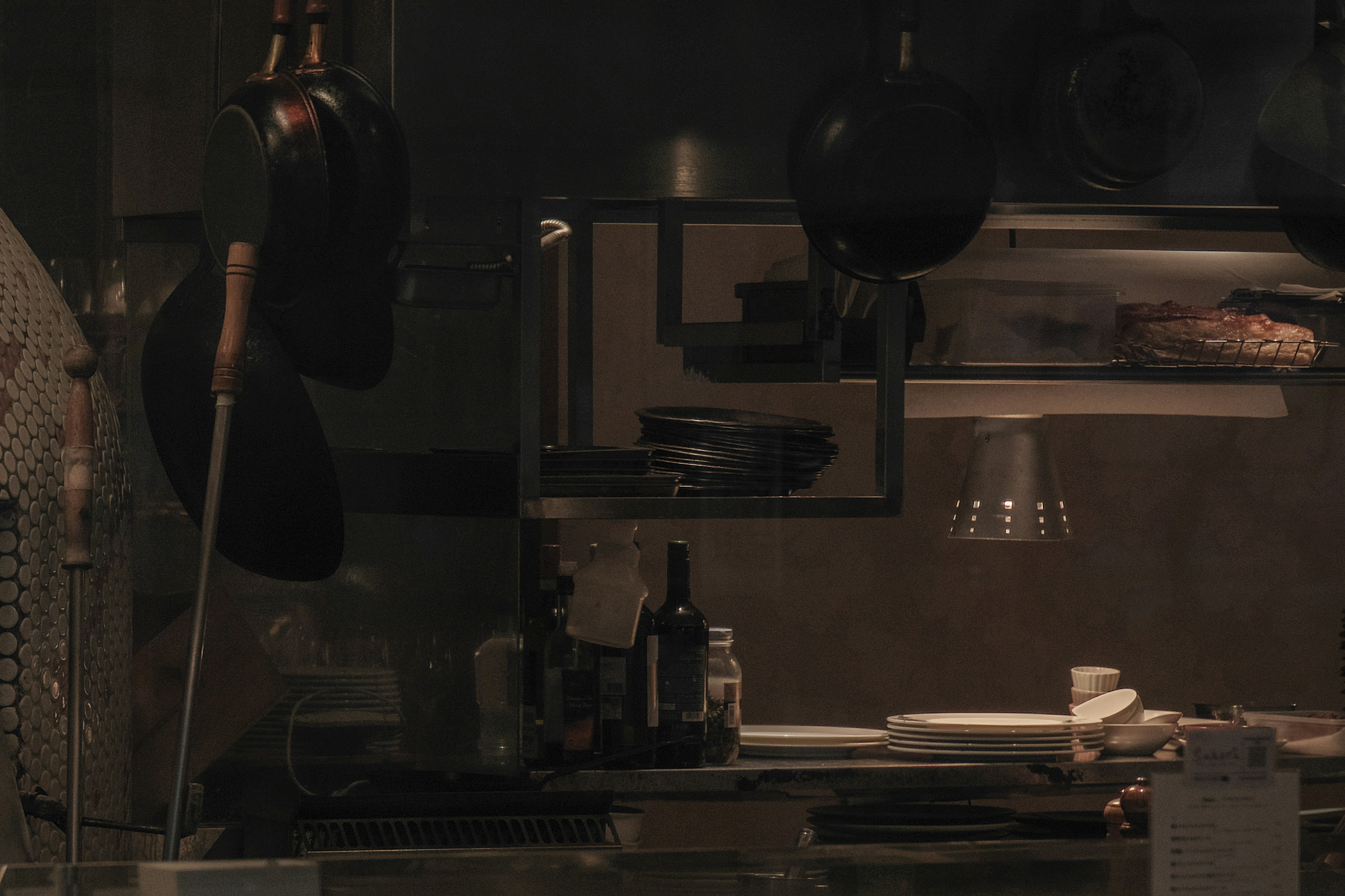 kitchen interior by a window with cookware and stacked dishes