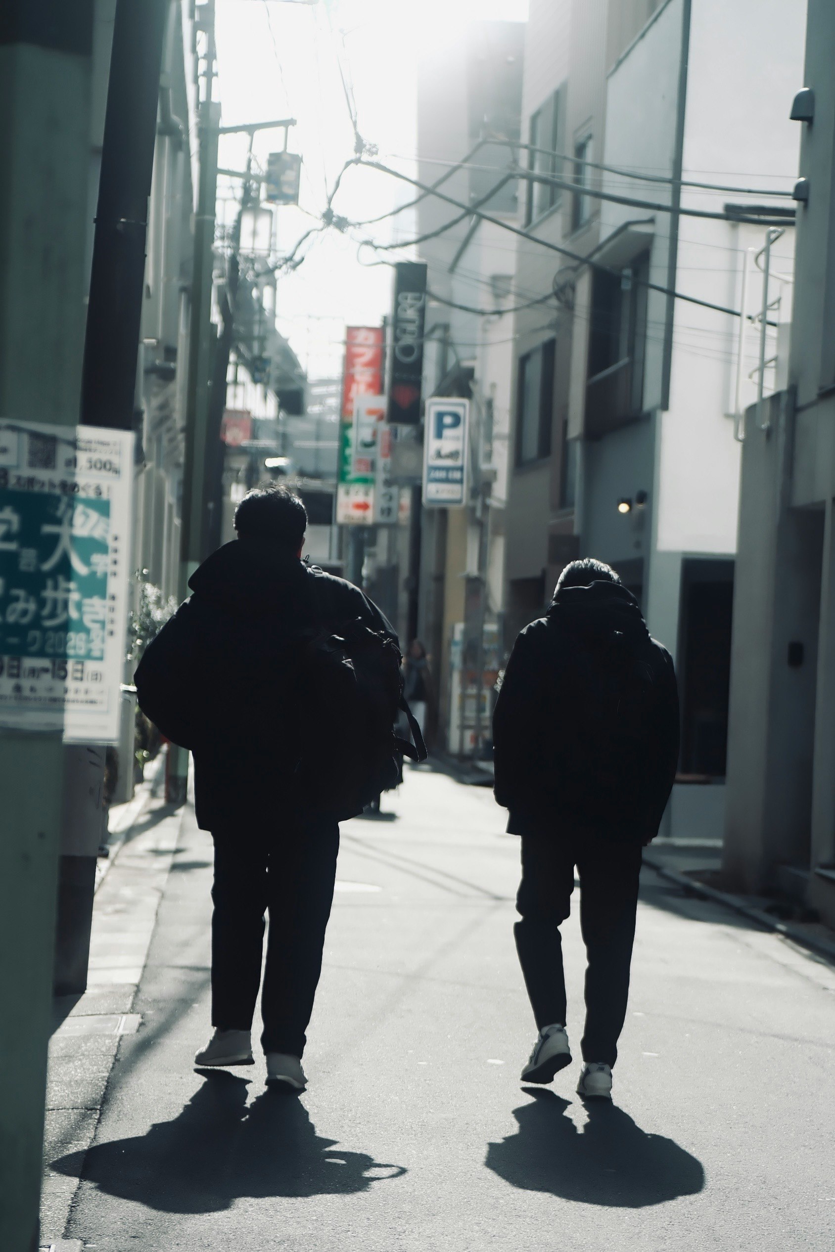 路地に並ぶ看板と人影のある街並み