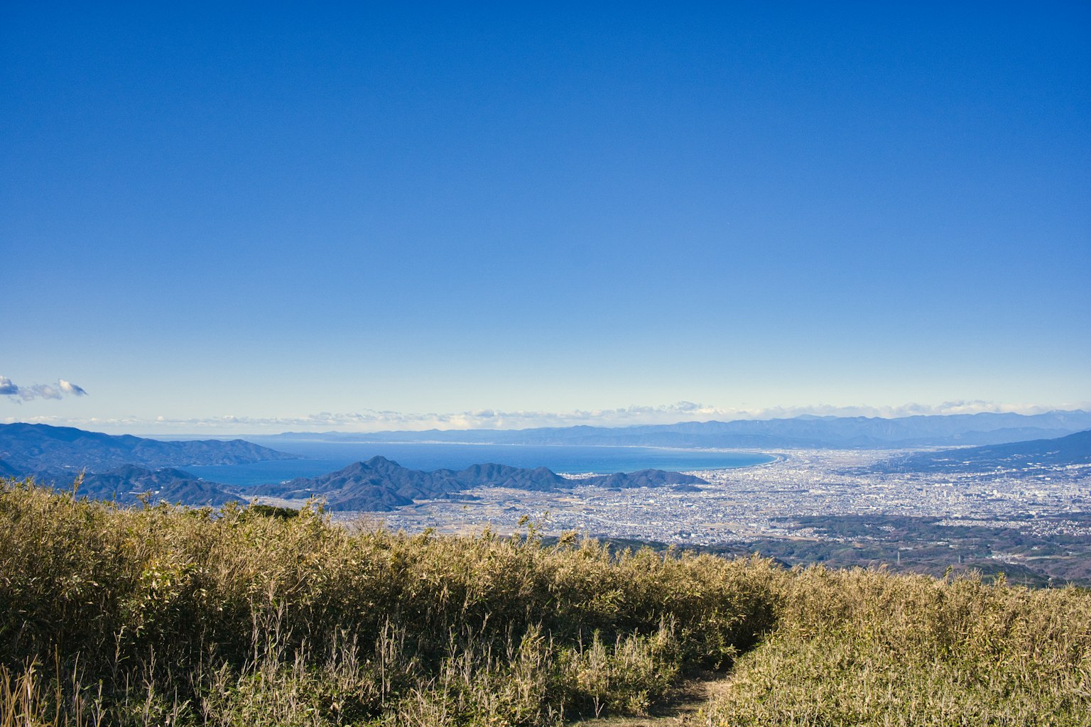 Paesaggio montano con vista sulla città sotto un cielo blu chiaro