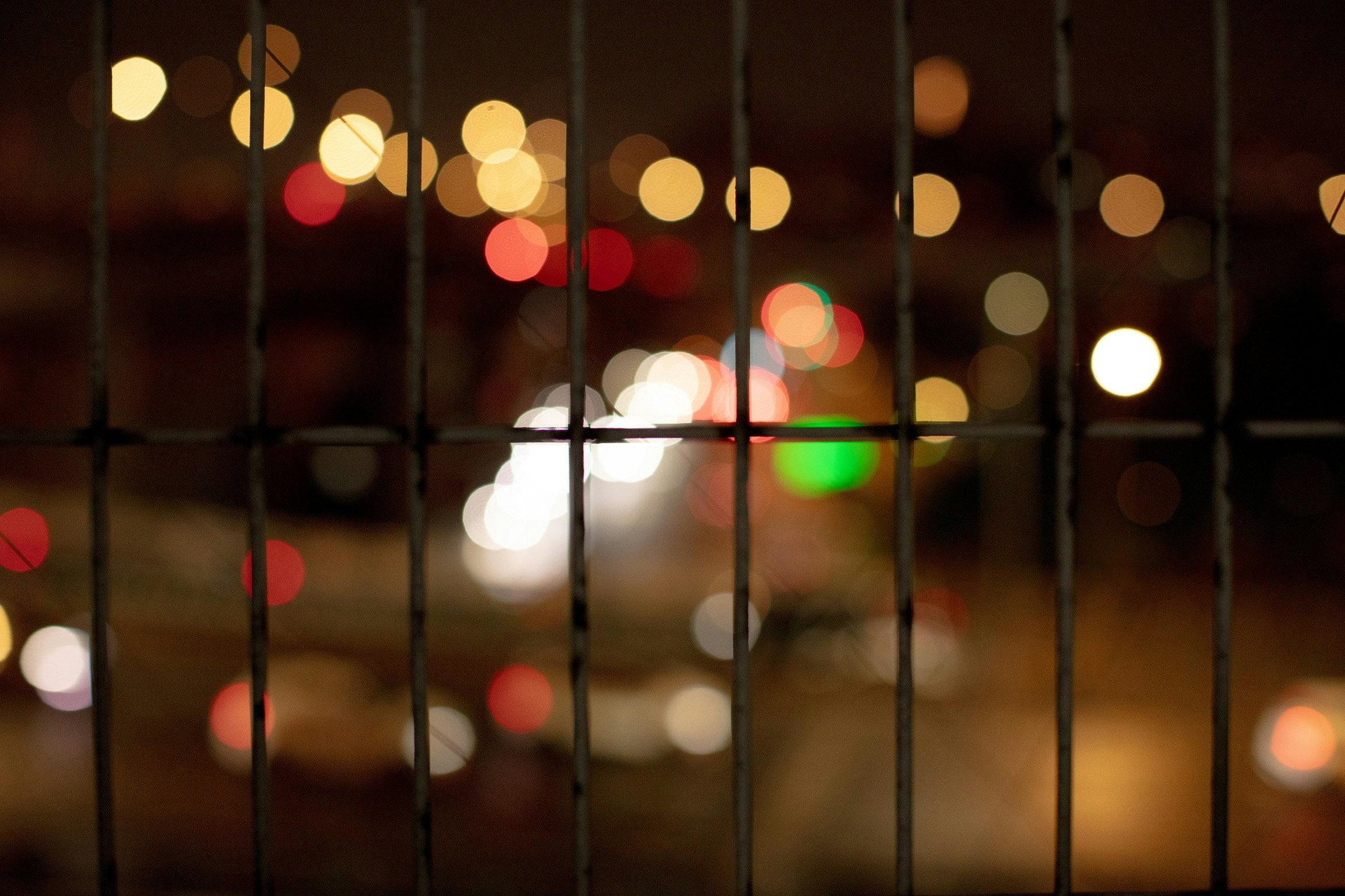 bokeh night city lights behind a fence