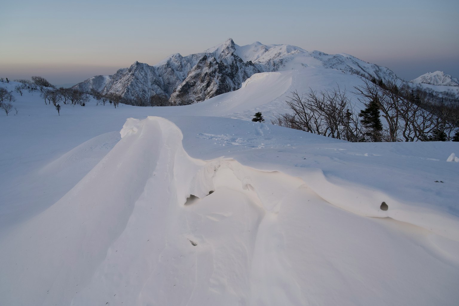 Schneebedeckte Berglandschaft mit gewellter Schneefläche