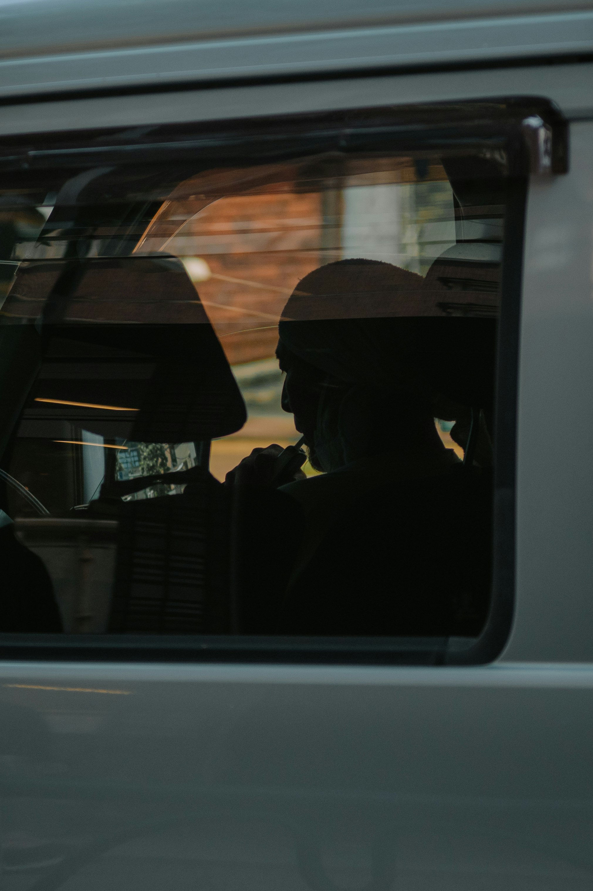 窓越しに見える人のシルエットが反射する車内