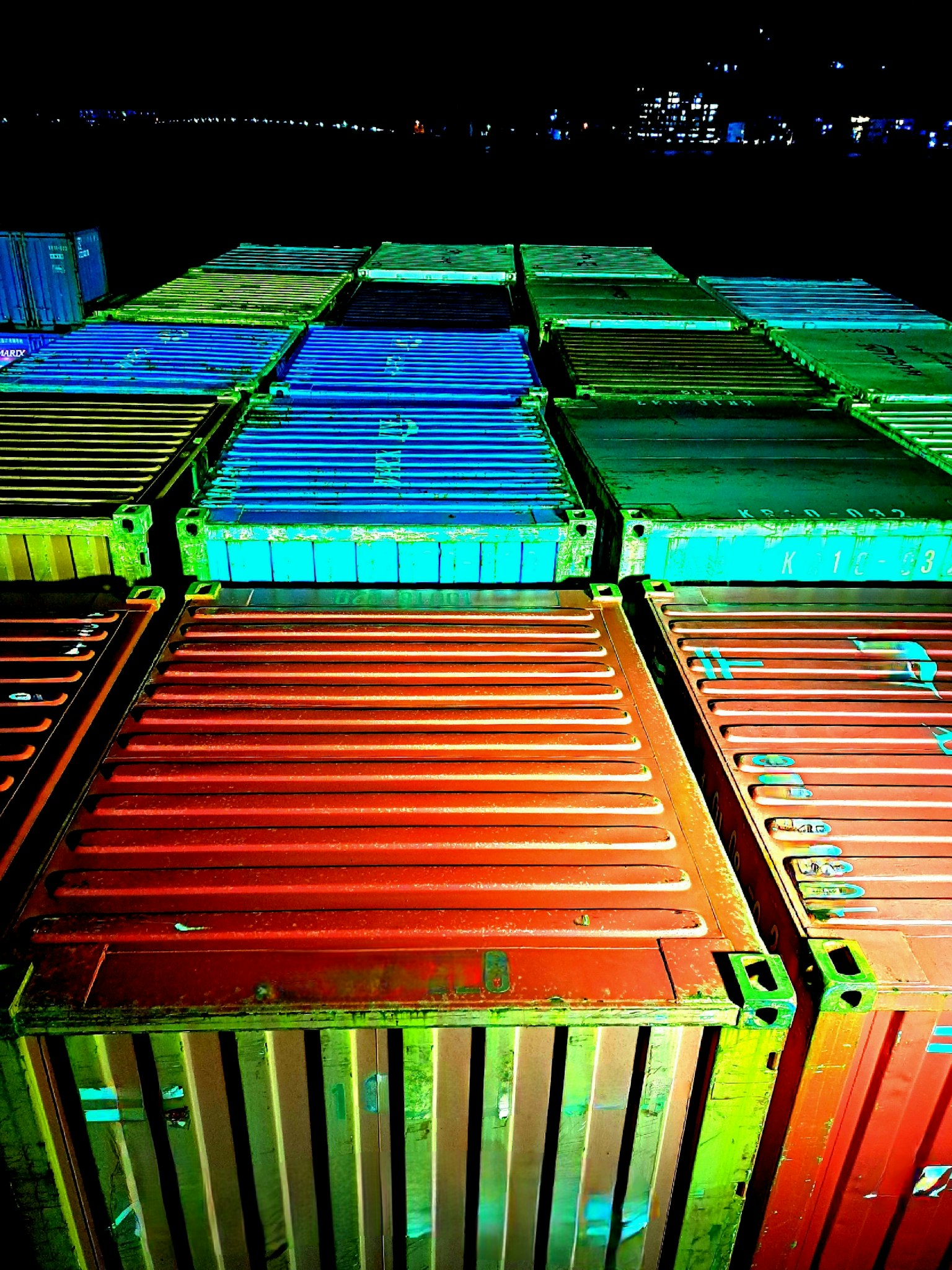 Bunte Versandcontainer in einem nächtlichen Hafen angeordnet