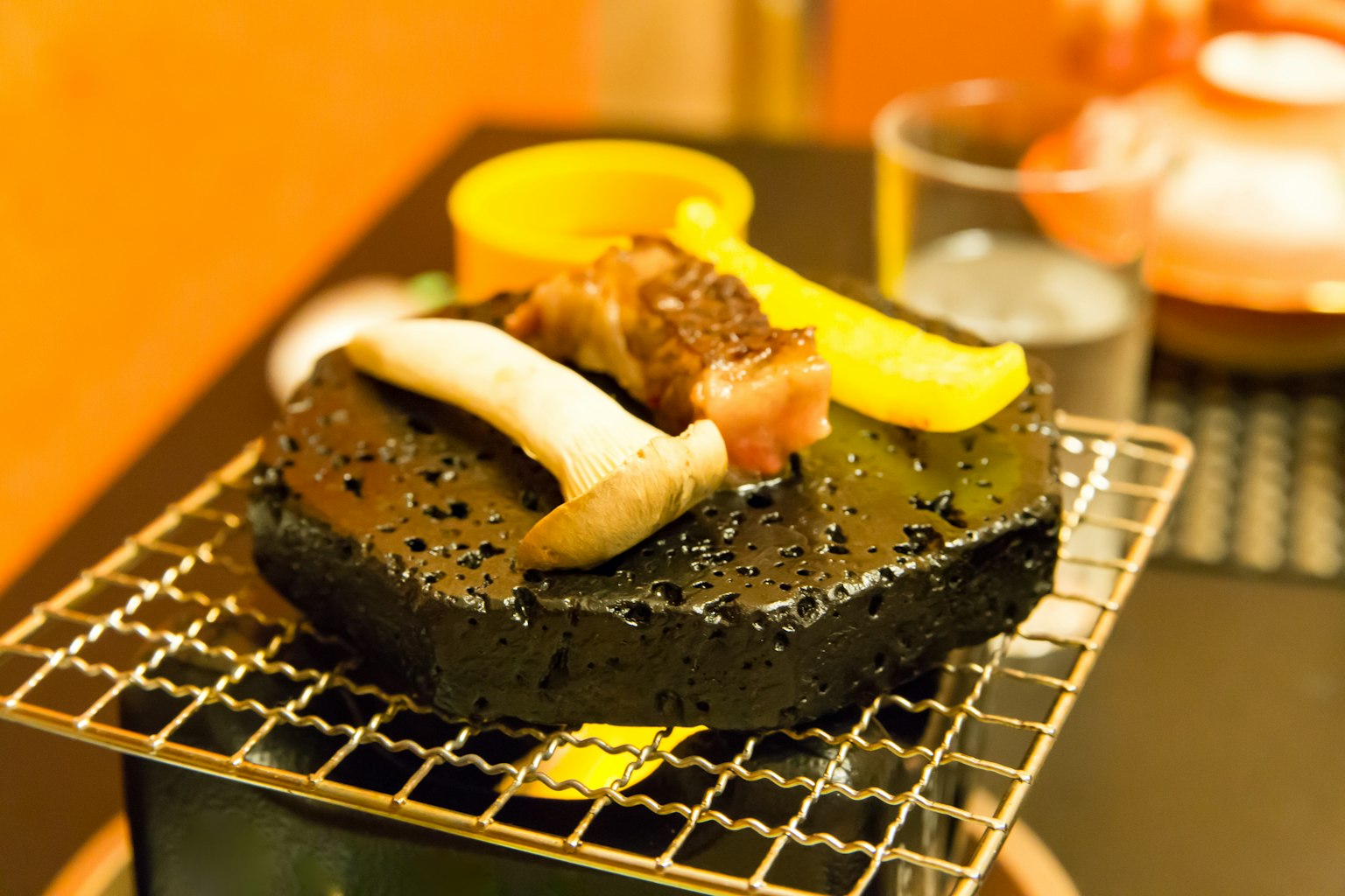 Grilled meat and vegetables on a black stone