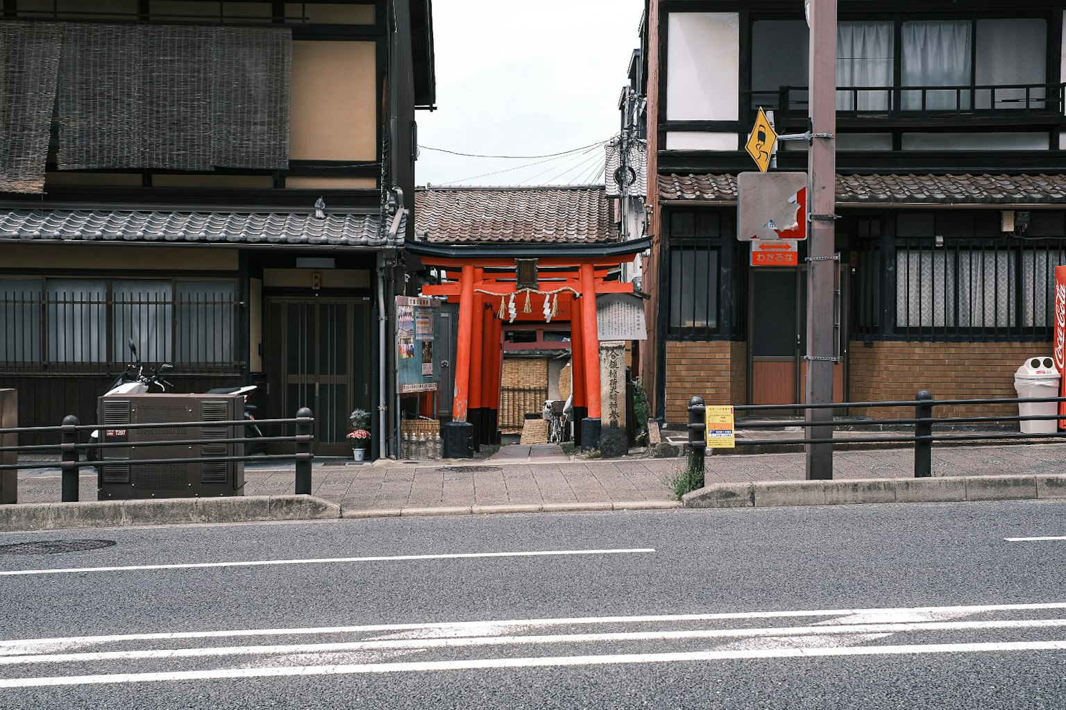 Street view featuring a red torii gate and traditional buildings