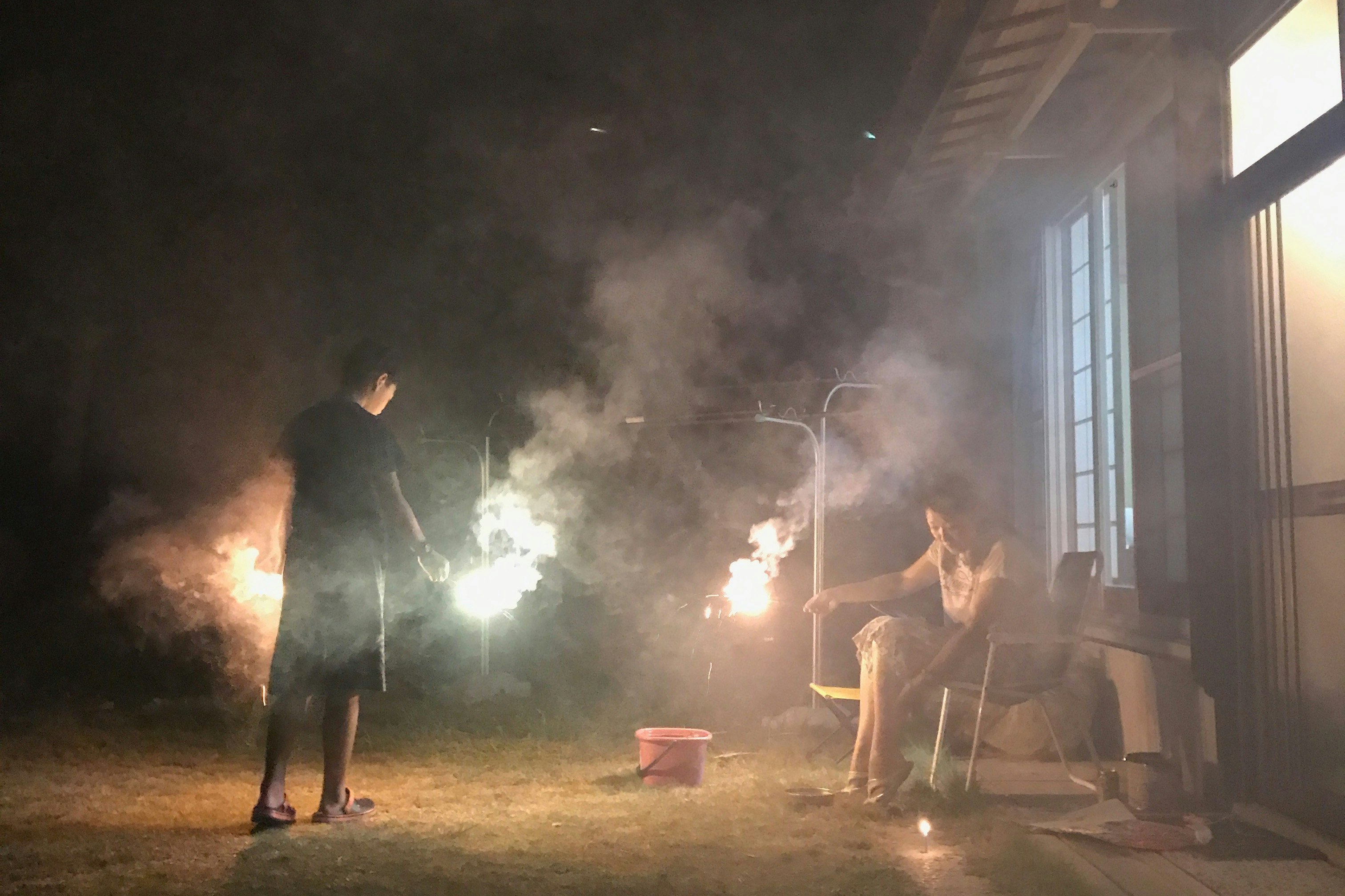煙の中で焚き火のような光が差す夜の屋外作業風景