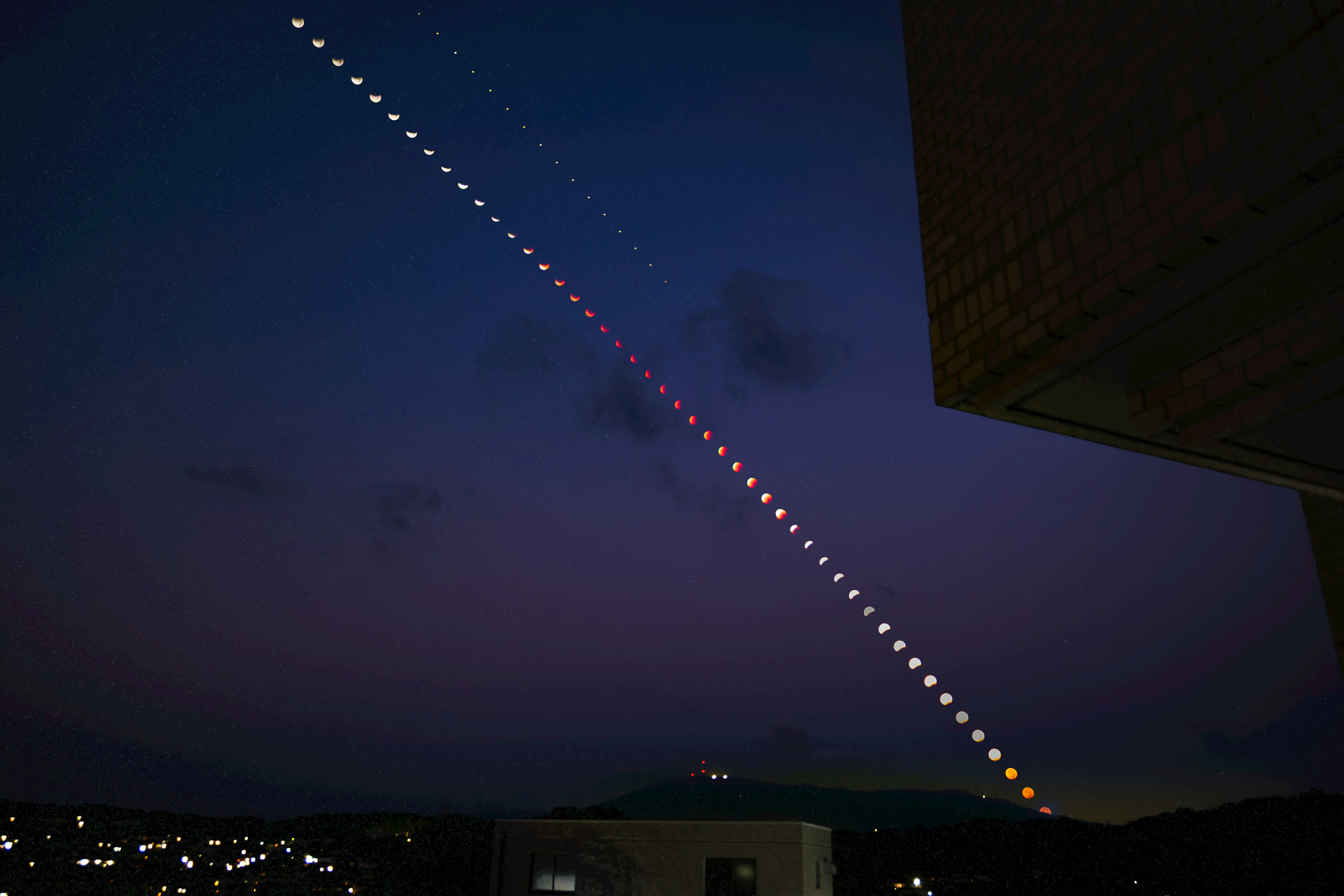 ligne pointillée de lumières dans le ciel nocturne avec une silhouette de bâtiment