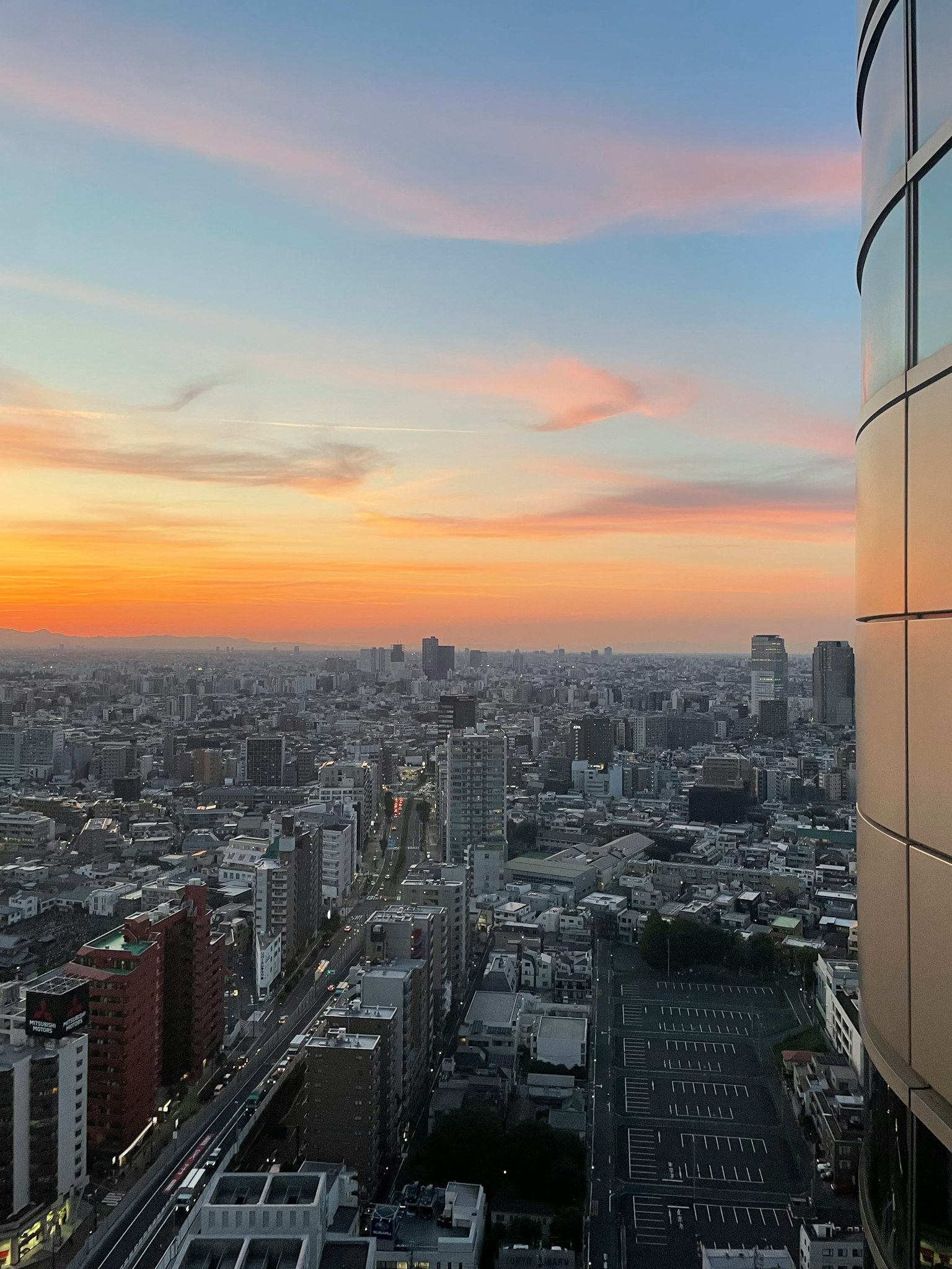 Vue de la ville au coucher du soleil avec un immeuble en premier plan