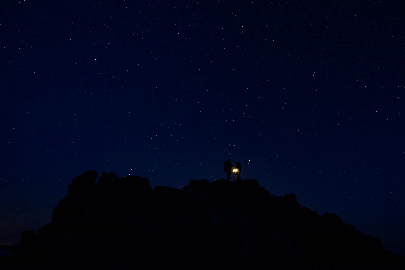 Silhouette of a lighthouse under a starry sky
