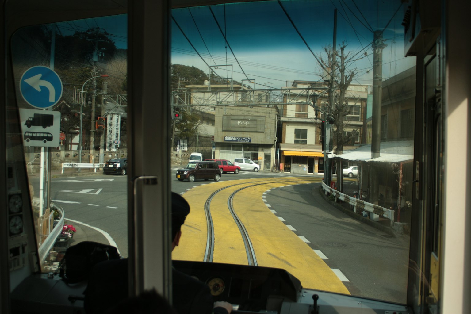 Vue depuis le siège du conducteur de tram montrant des rails courbés et des bâtiments environnants