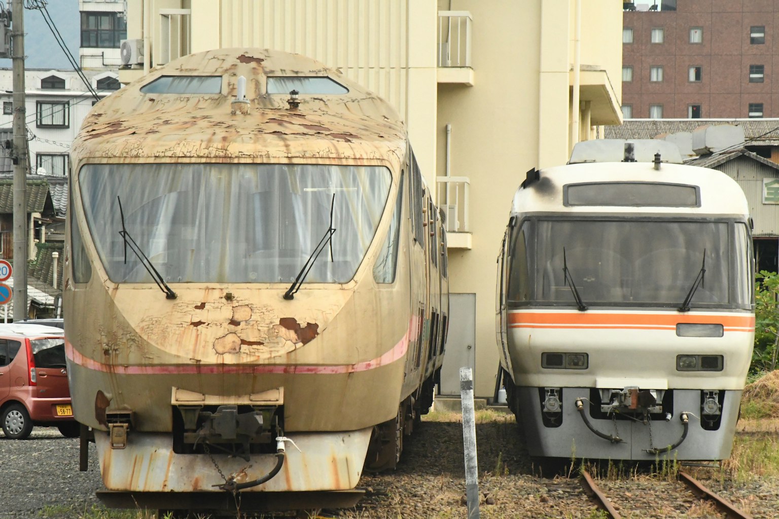 Un tren viejo oxidado al lado de un tren moderno en una estación