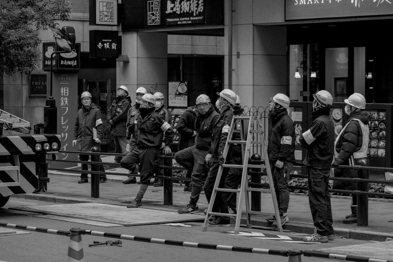 Travailleurs de la construction en casques et uniformes dans une rue de la ville en noir et blanc