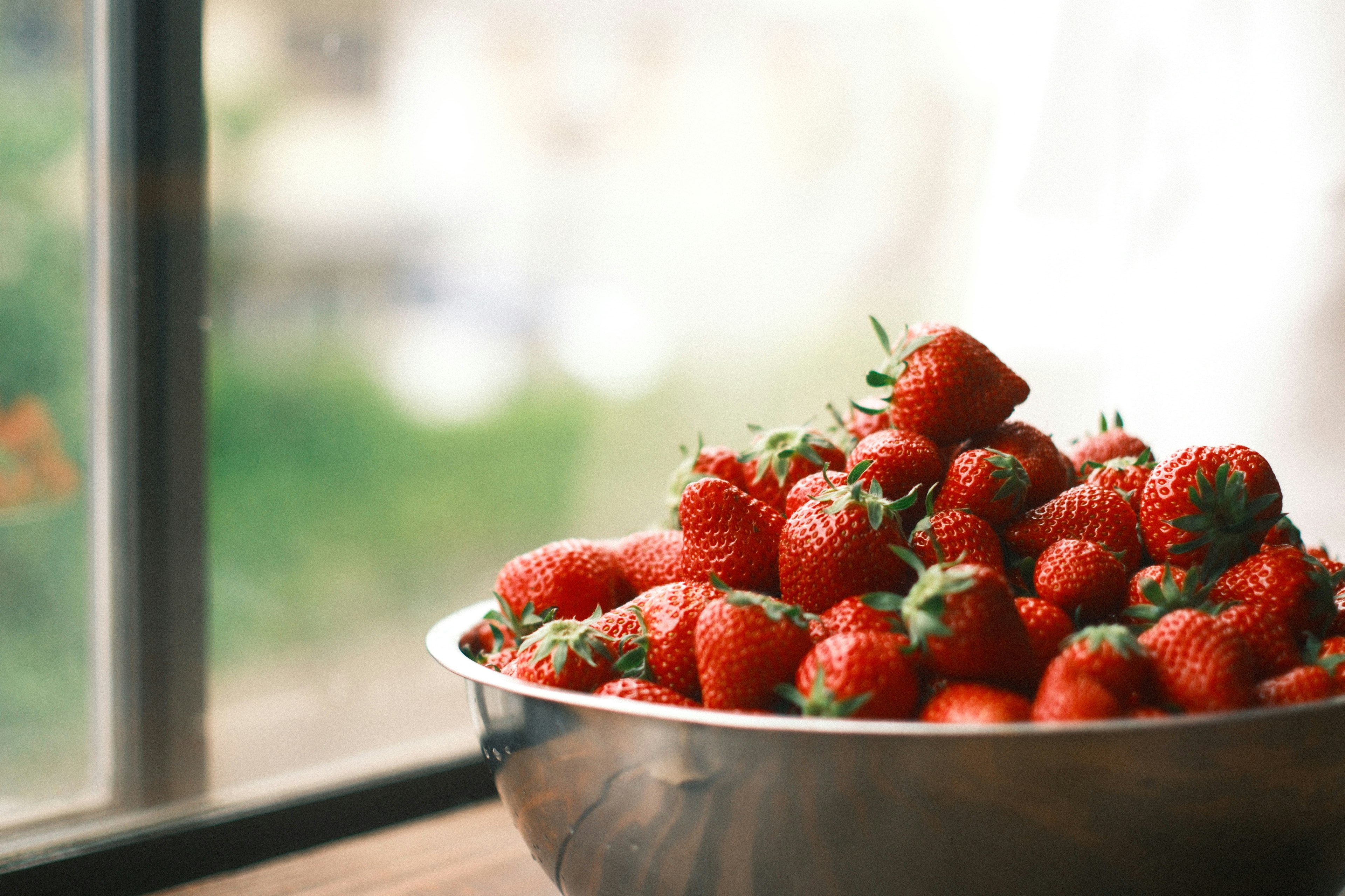 fresas en un bol junto a una ventana
