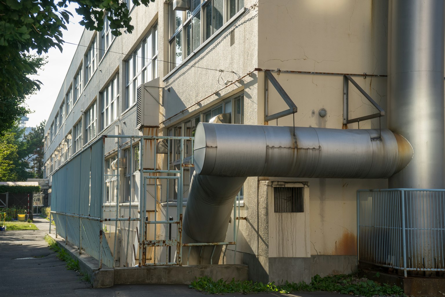 Exterior view of a factory with metal piping