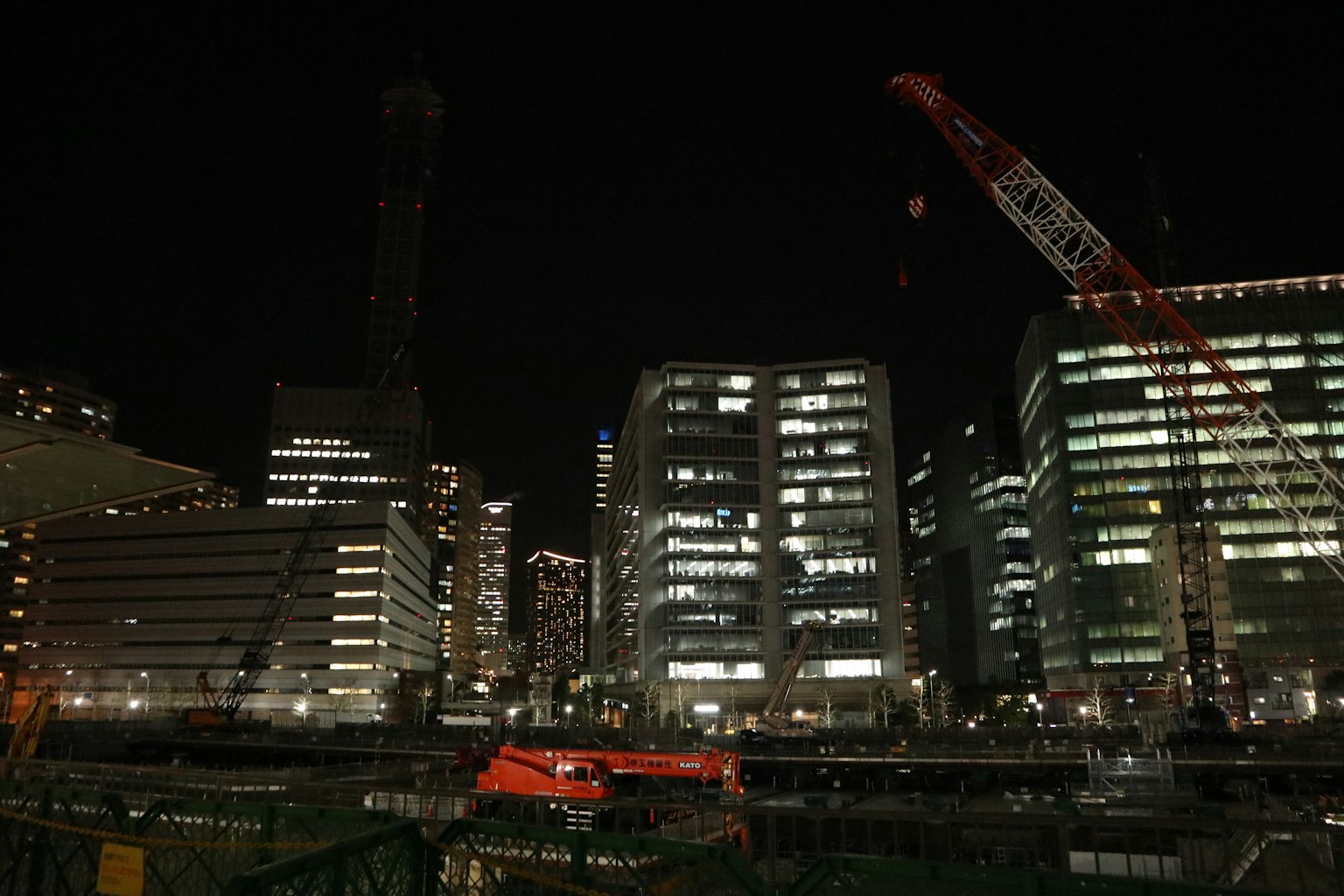 夜间城市景观包含摩天大楼和起重机