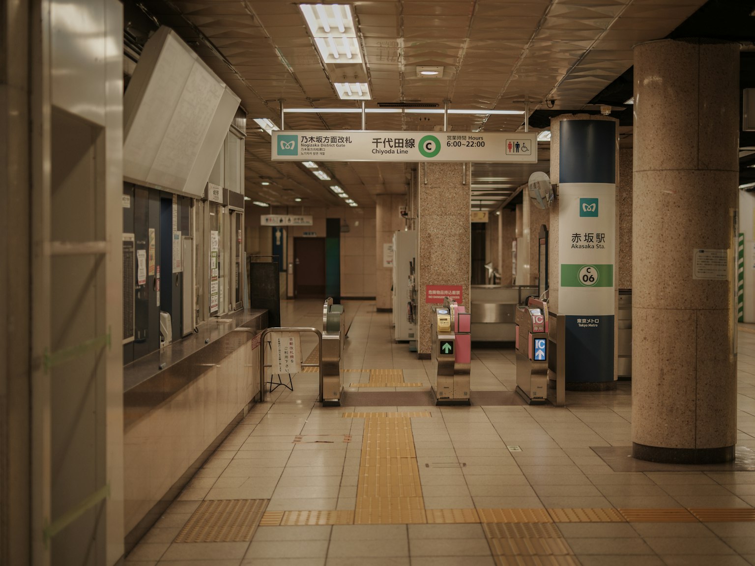 Quiet subway station interior featuring ticket machines and turnstiles