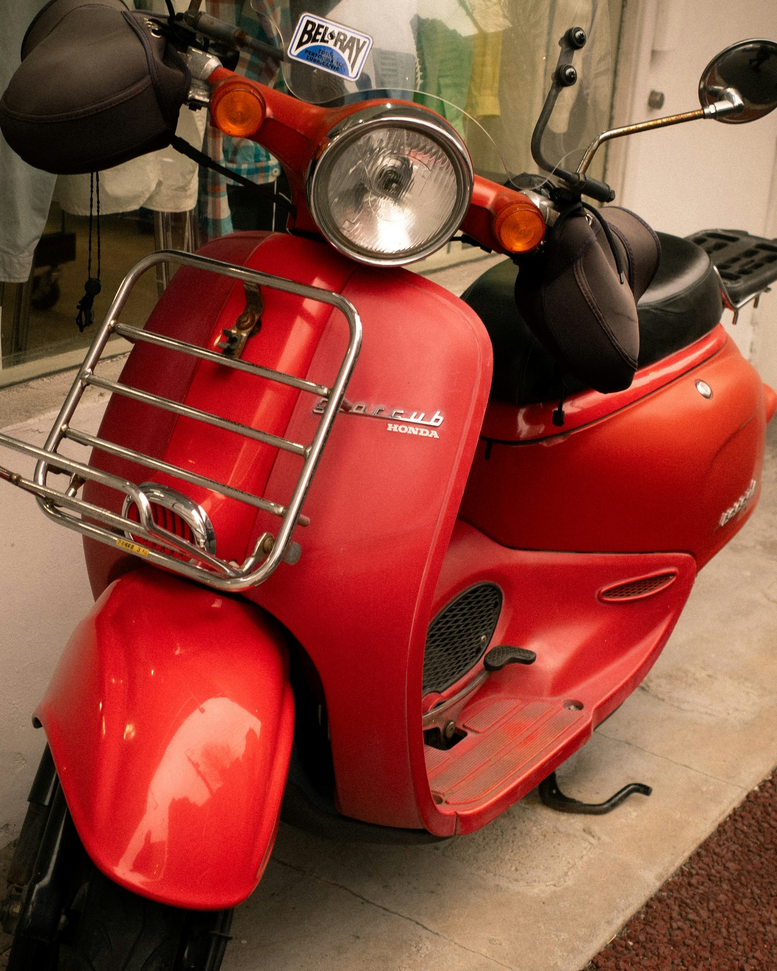 Close-up of a red scooter featuring chrome bumper and seat