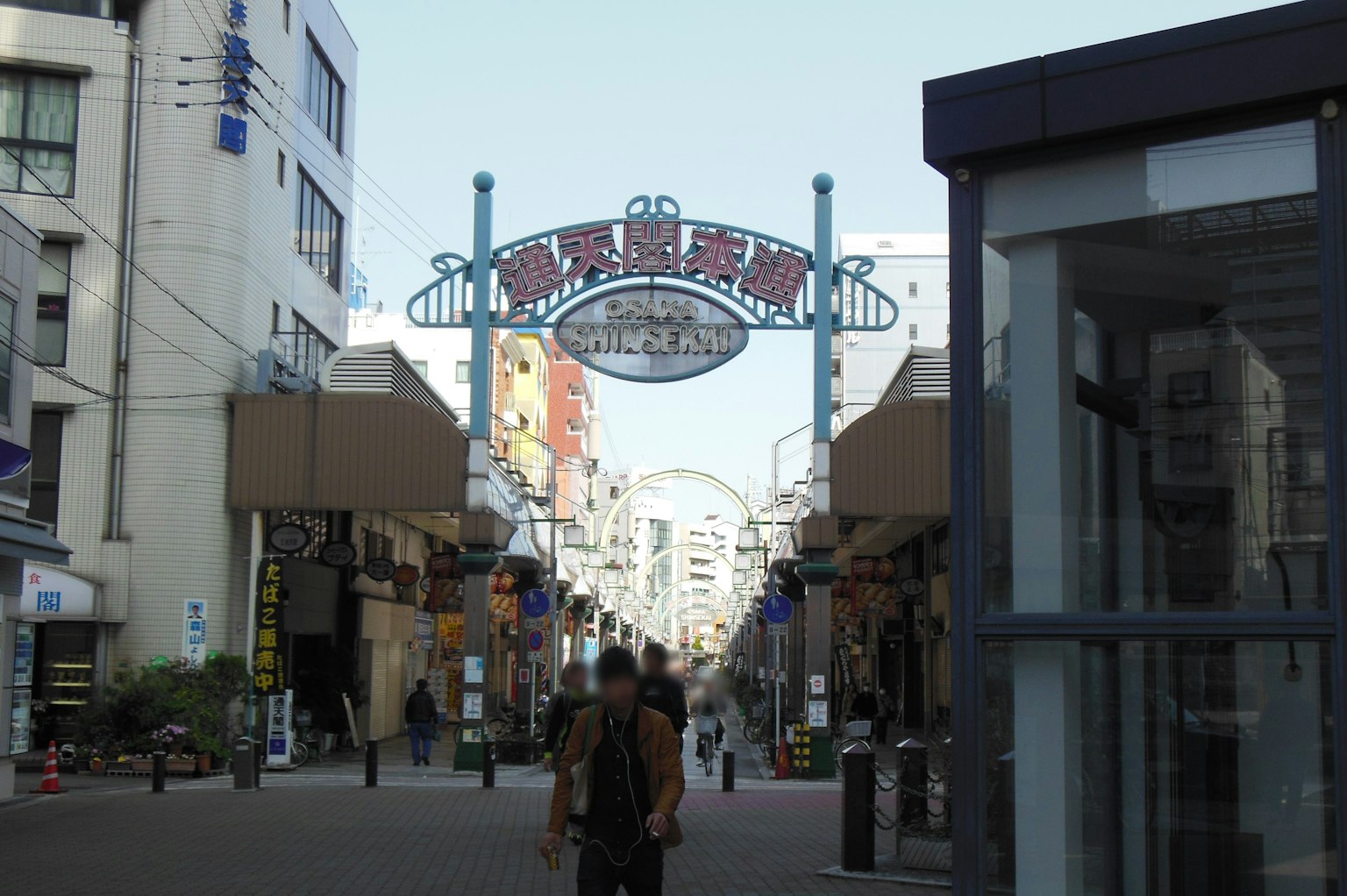Street featuring an archway sign of a shopping district