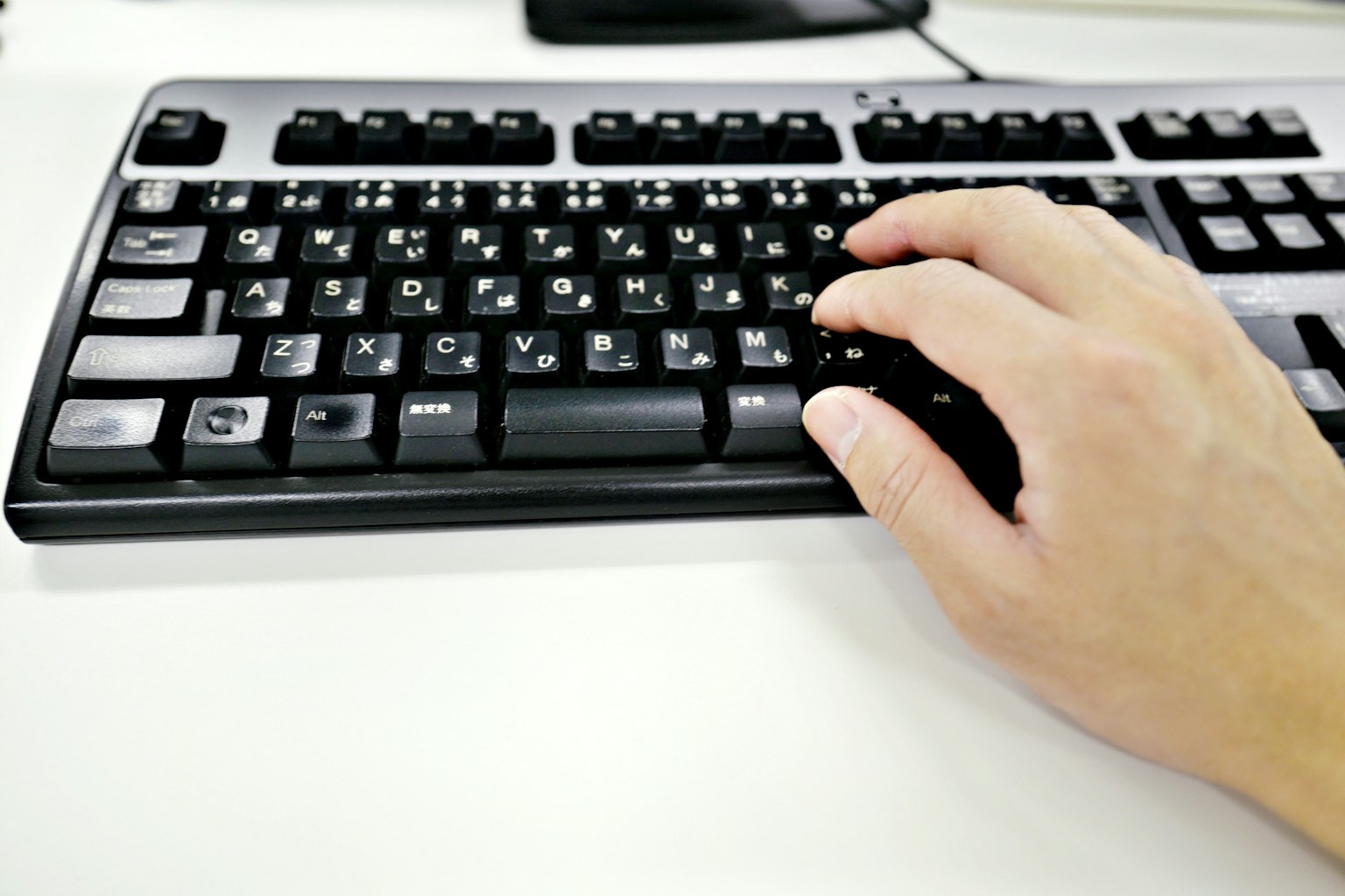 Une main tapant sur un clavier d'ordinateur noir