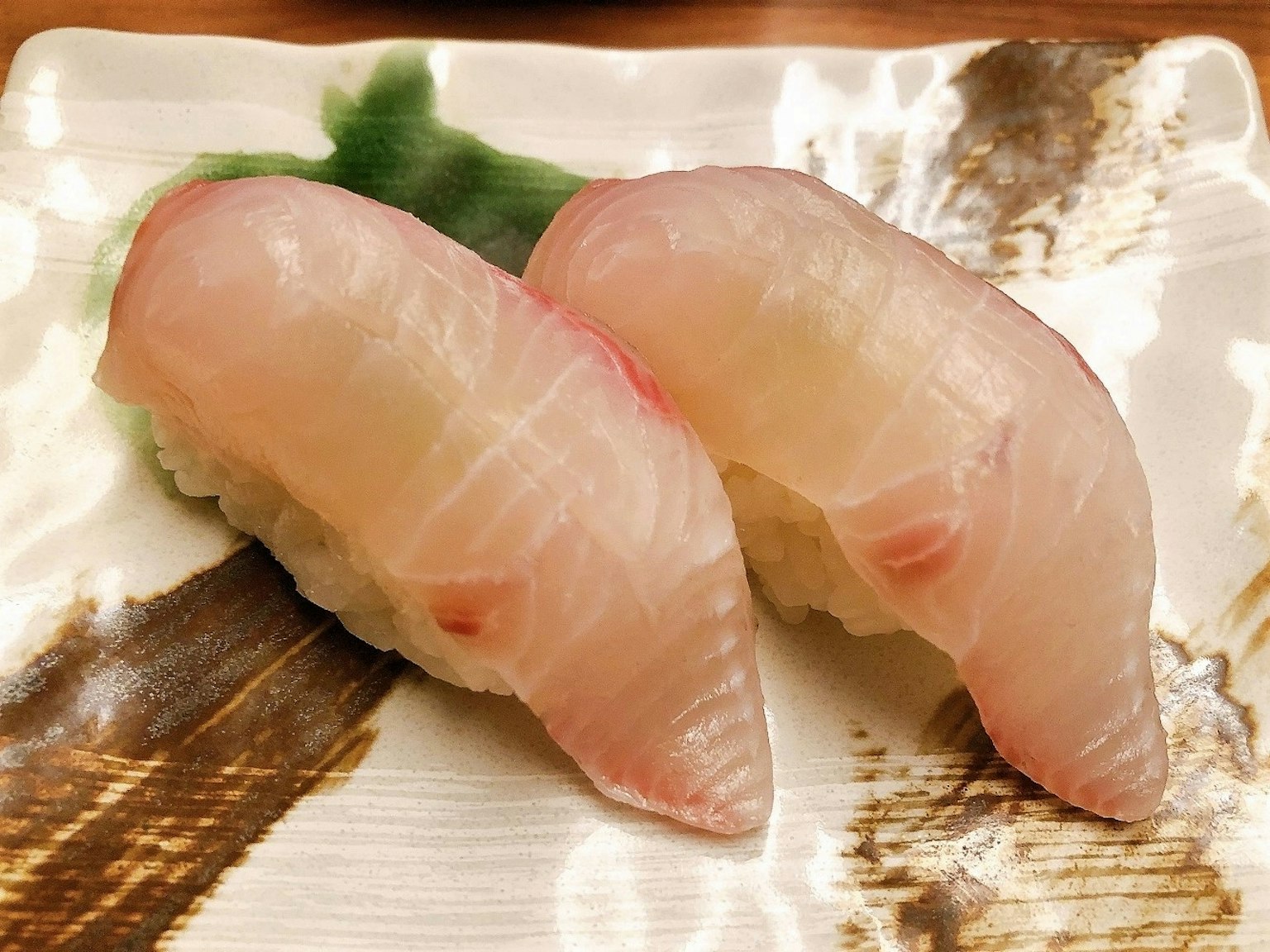 ซูชิสองชิ้นบนจานสีขาว