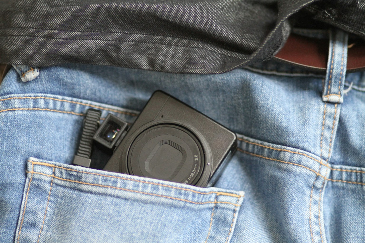 Macchina fotografica riposta nella tasca di jeans in denim