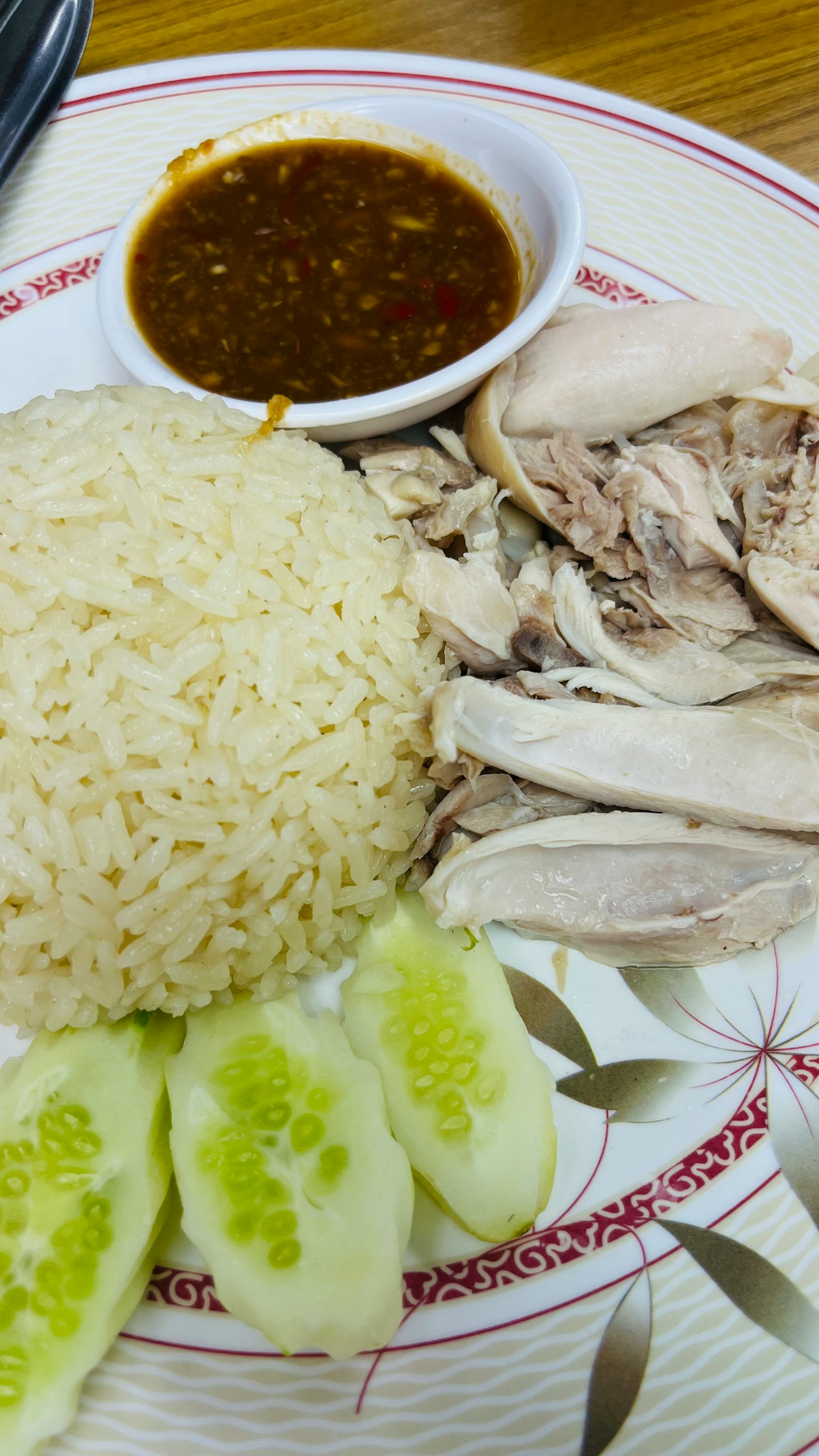 Teller mit gedämpftem Reis mit geschnittenem Hähnchen Gurke und Dip-Sauce
