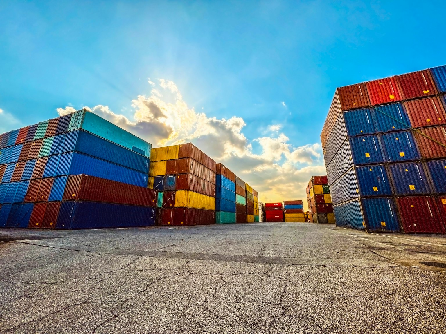 Bunte Versandcontainer unter einem hellblauen Himmel gestapelt