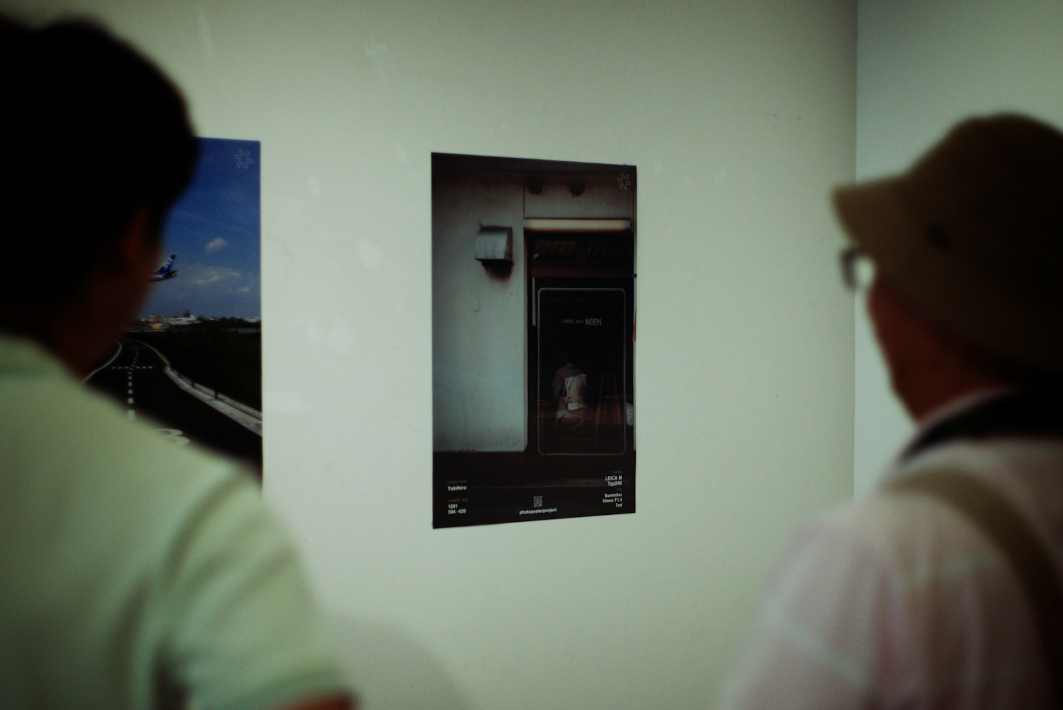 Deux spectateurs observant une photographie exposée dans une galerie d'art