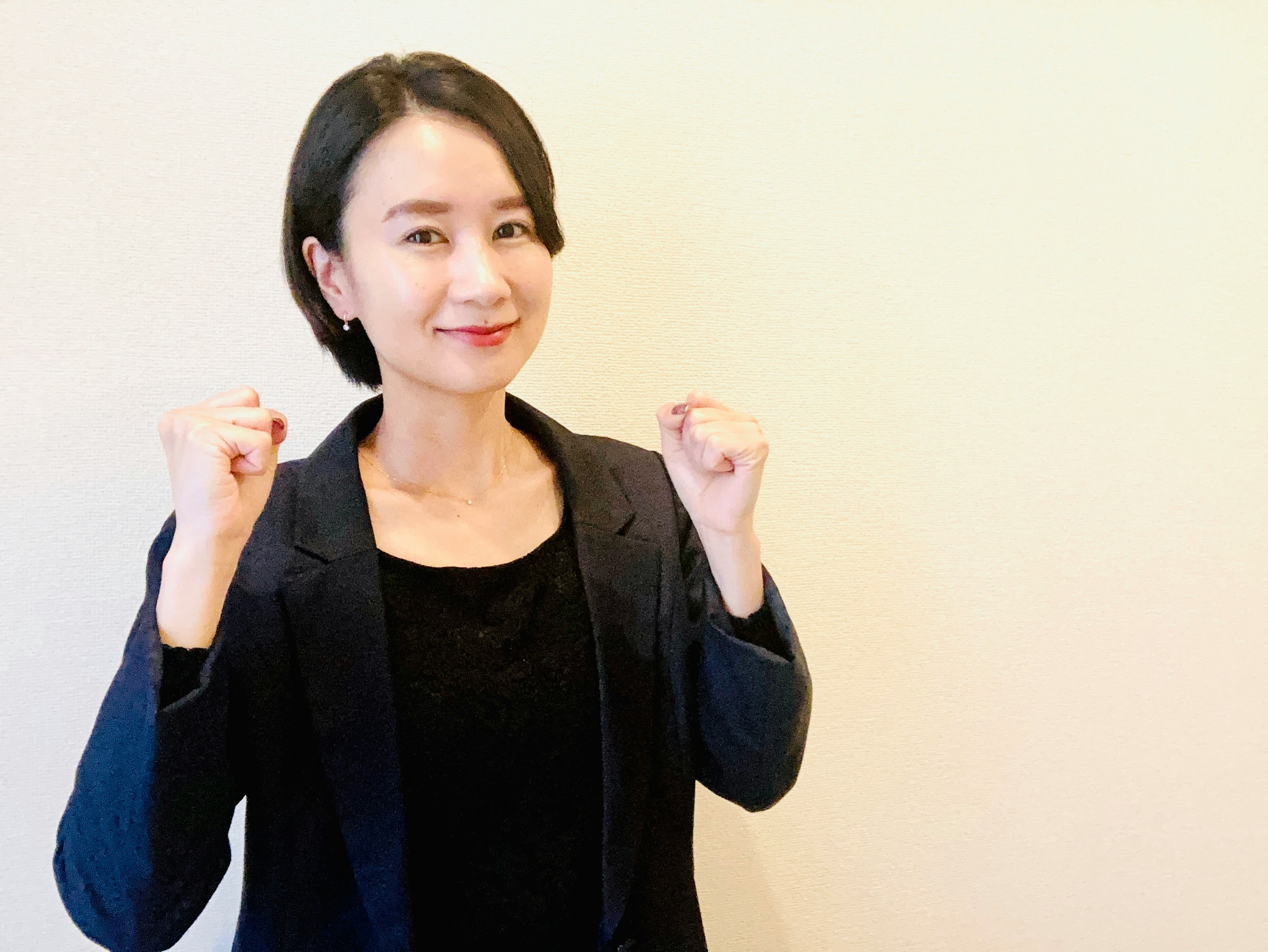 穿黑色西裝外套的女性做握拳姿勢